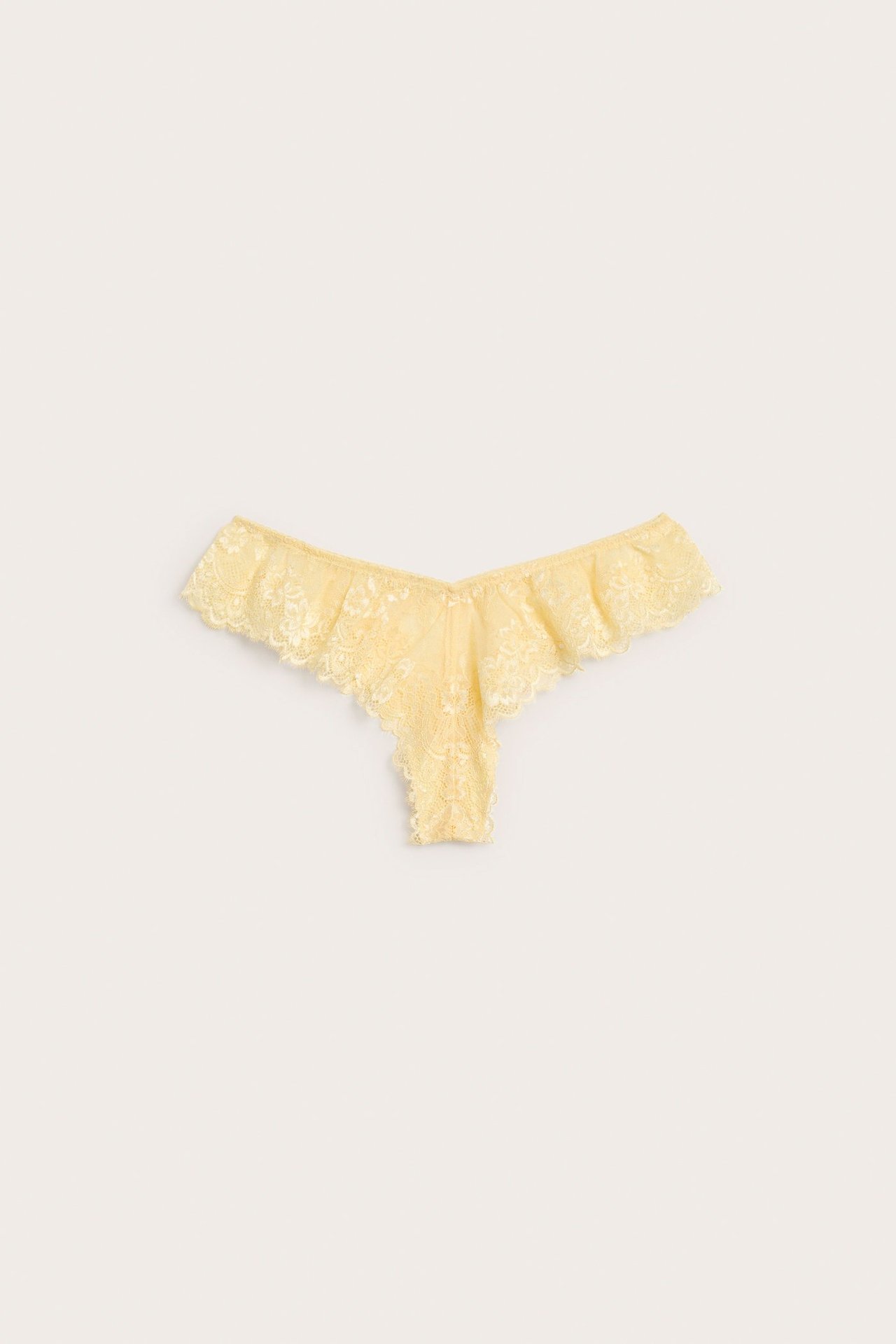 Widok z przodu jasnych żółtych koronkowych fig cheeky z falbanką w talii.