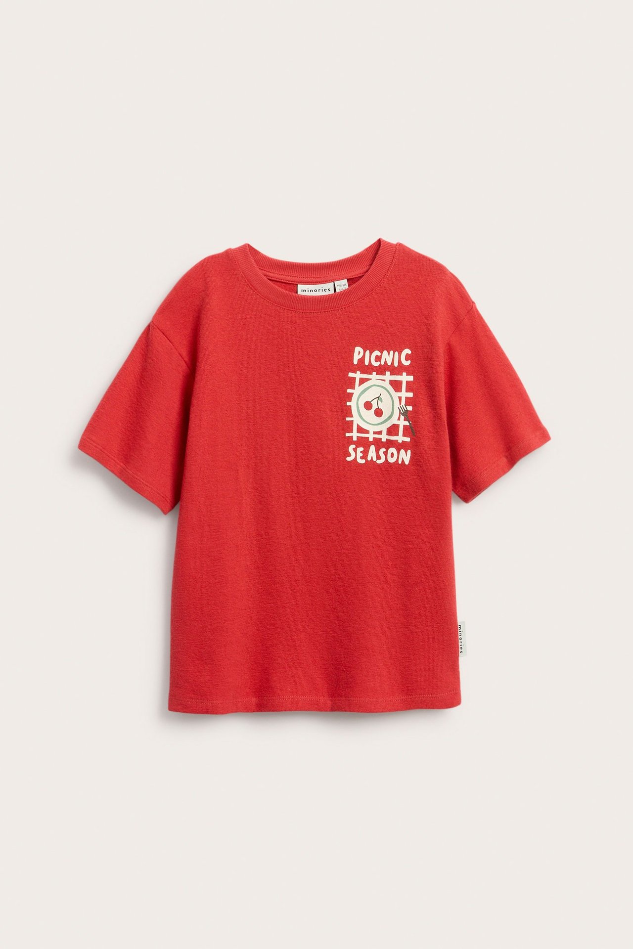 Framifrån, röd kortärmad t-shirt i bomull för barn med "PICNIC SEASON"-tryck framtill.