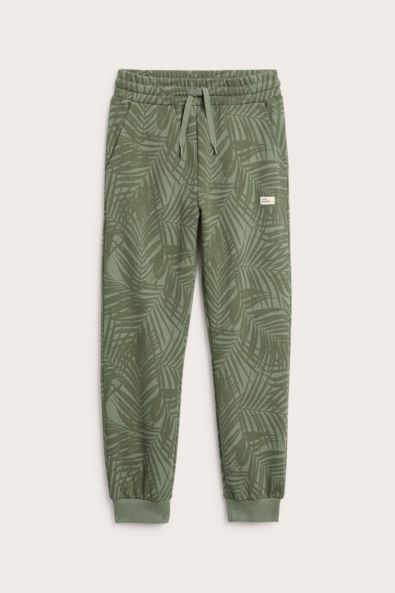 Edestä: vihreät puuvillaiset collegehousut palmukuvioinnilla, joustovyötärö, nyöri ja resorit.