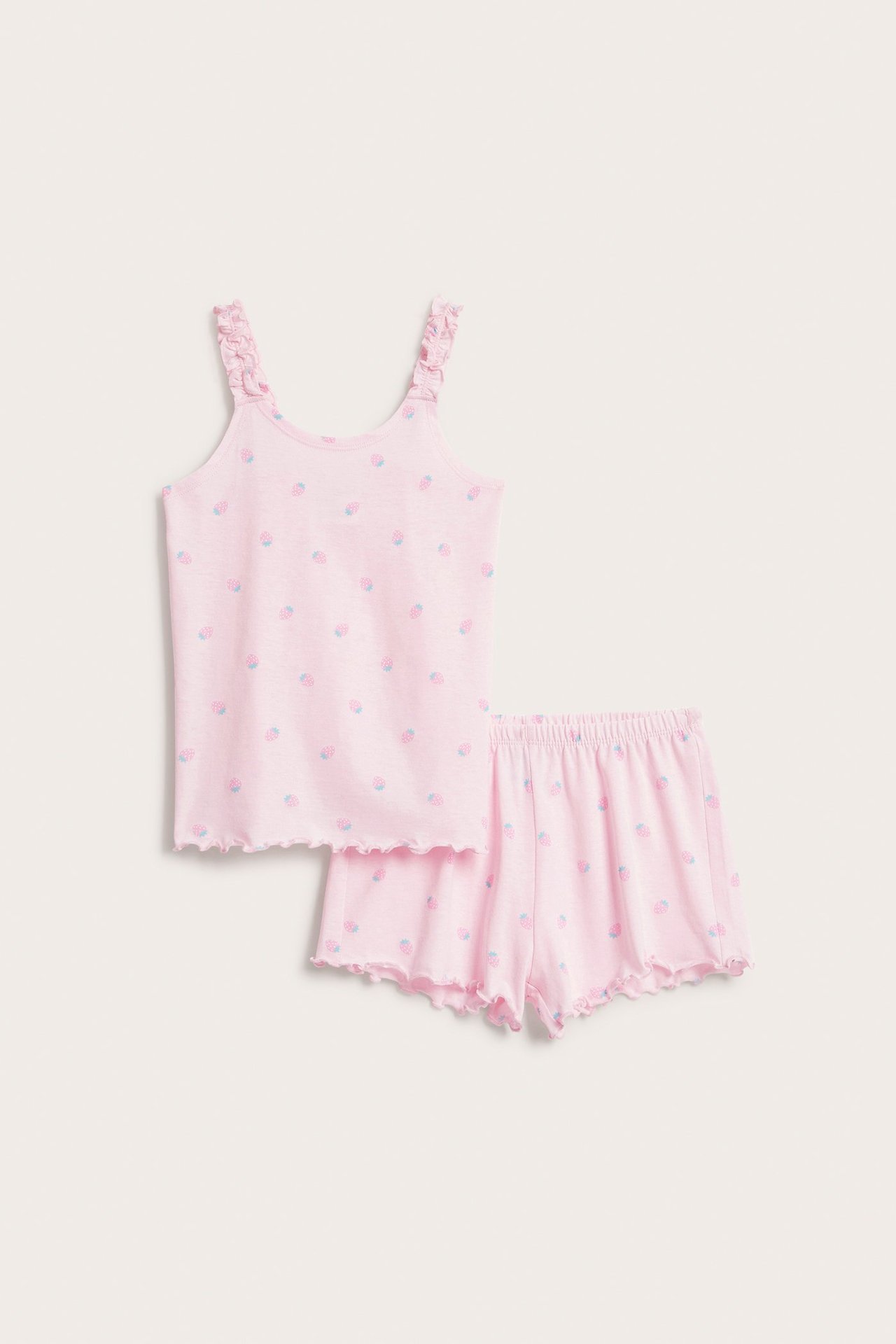 Widok z przodu: Różowa bawełniana piżama dla dzieci z truskawkowym wzorem, falbankowymi ramiączkami i brzegami.