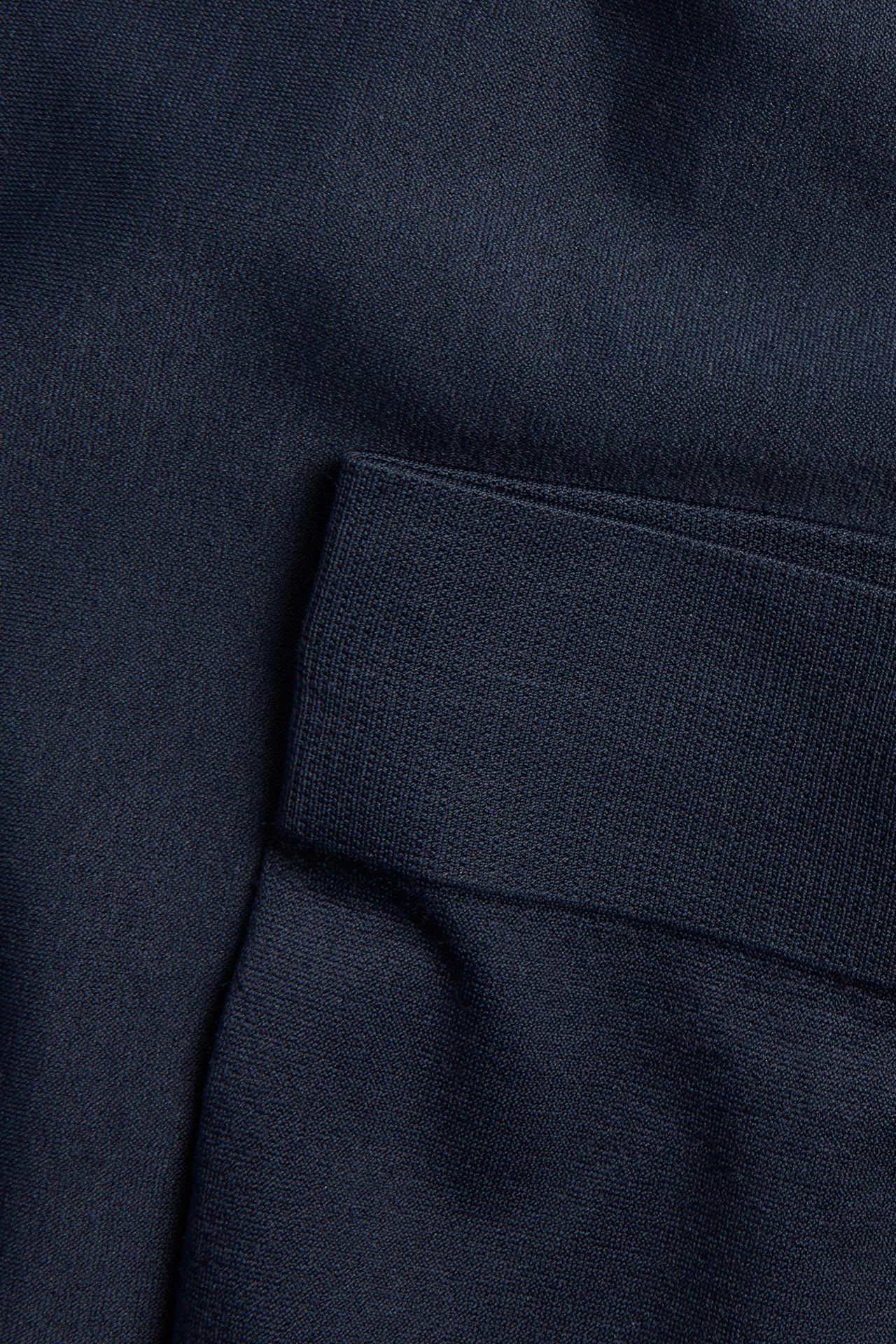 Närbild av mörkblå enfärgad hipstertrosas tyg, tillverkat av en polyamid- och elastanblandning.