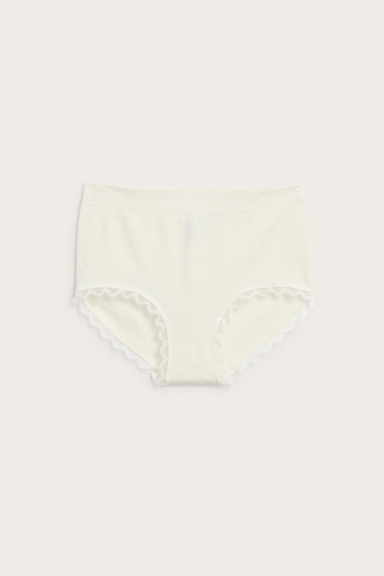 Framifrån, offwhite seamless höga hipstertrosor med vit spetskant.