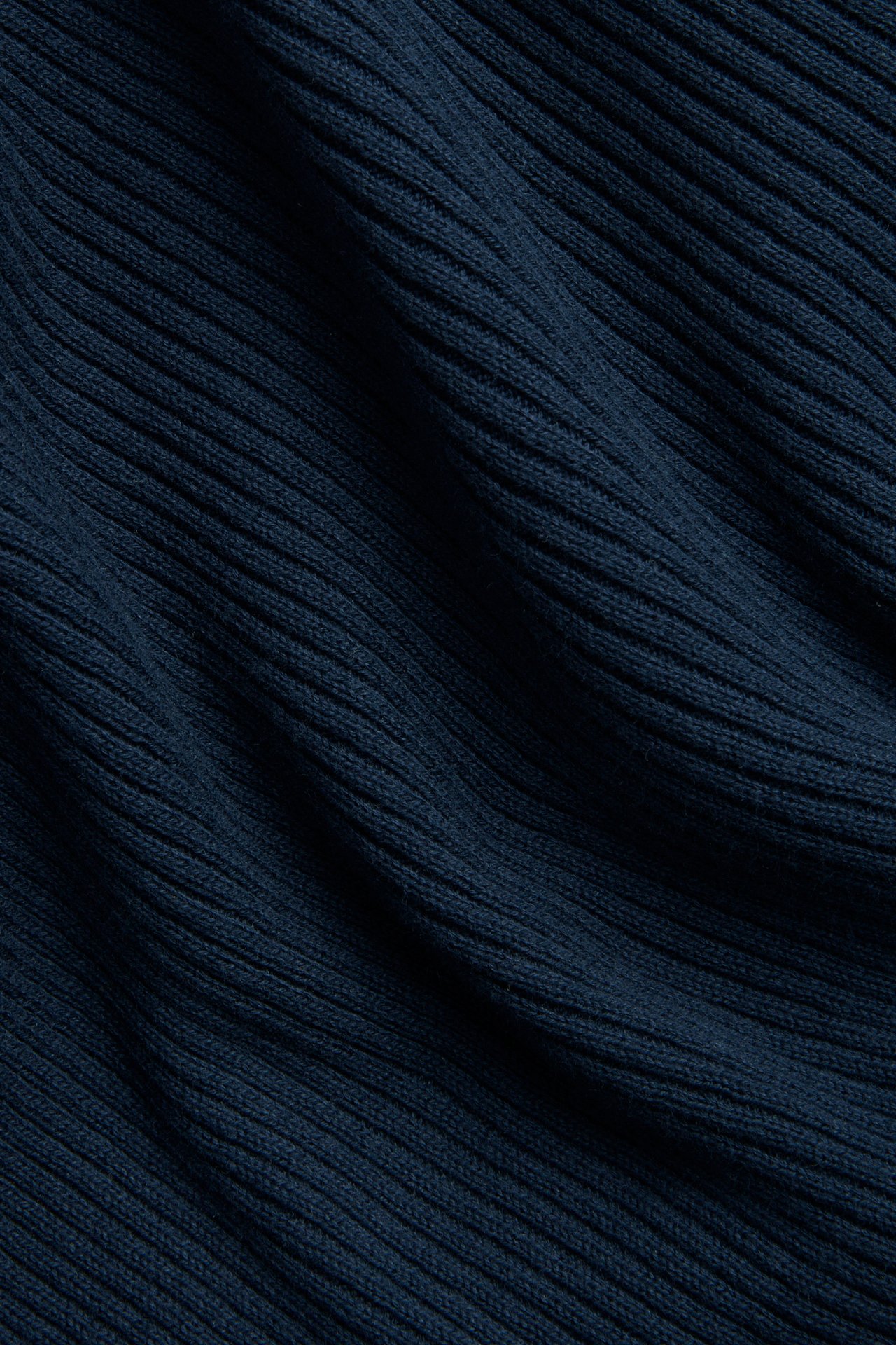 Nærbilde av et mørkeblått ribbestrikket bomullsgenserstoff.