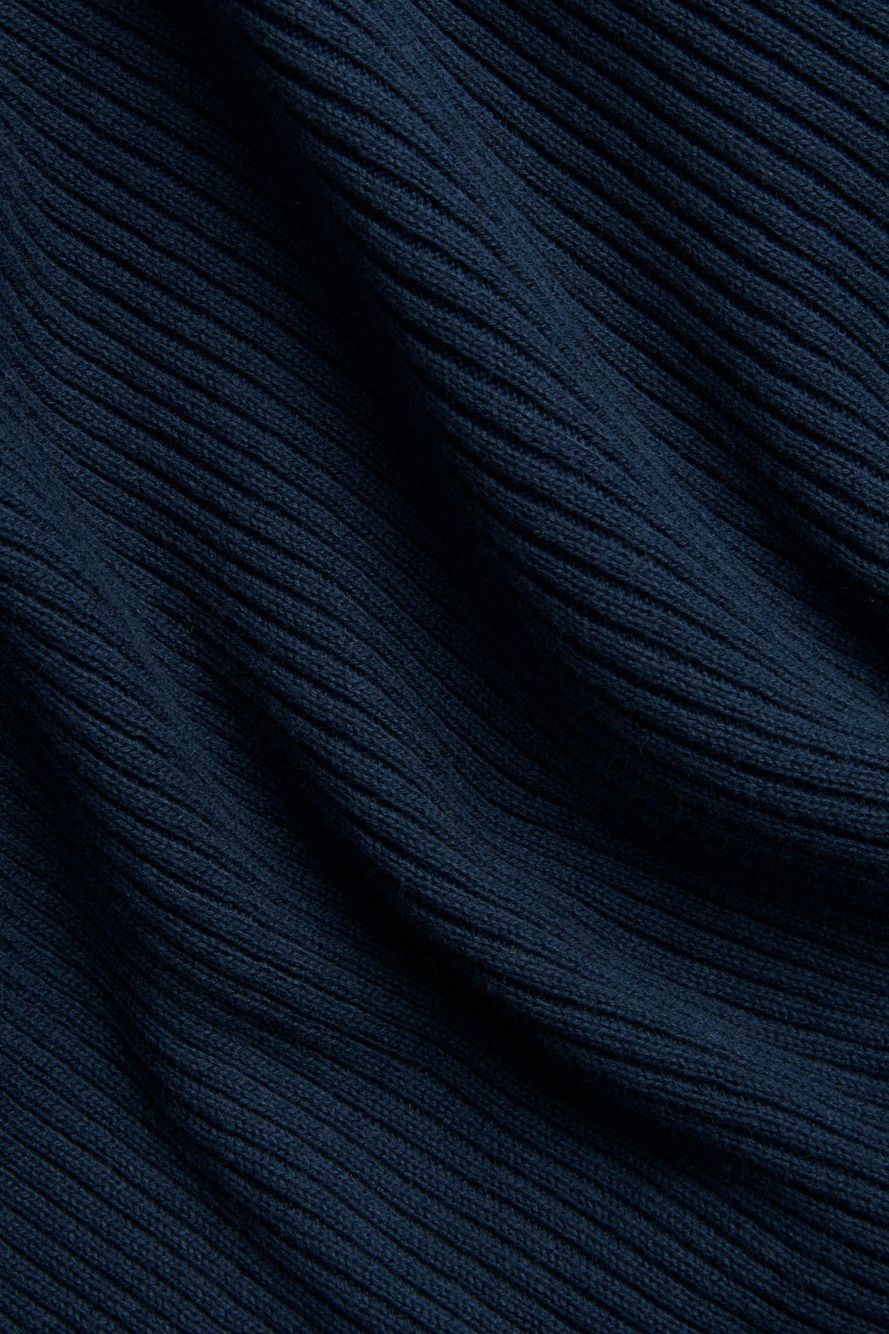 Zbliżenie na ciemnoniebieski, prążkowany materiał bawełnianego swetra.