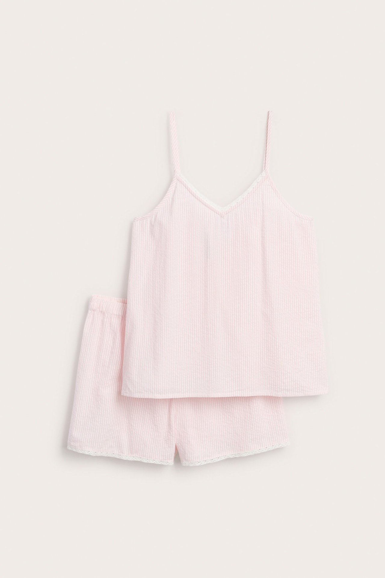 Widok z przodu różowo-białego pasiastego kompletu piżamy: top i szorty z bawełny, z białą koronką.