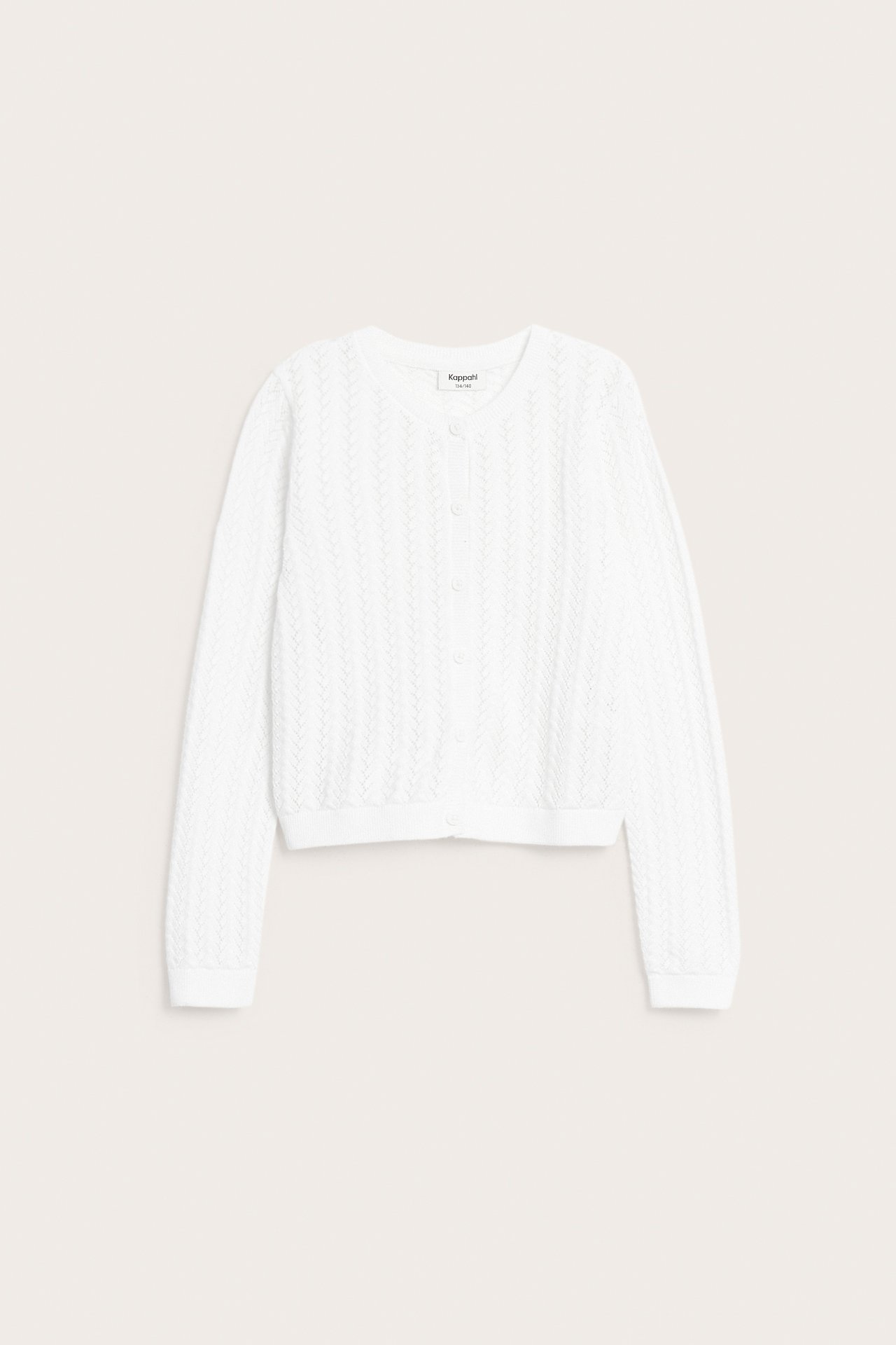 Framifrån, vit mönsterstickad kofta i bomull med knappar framtill.