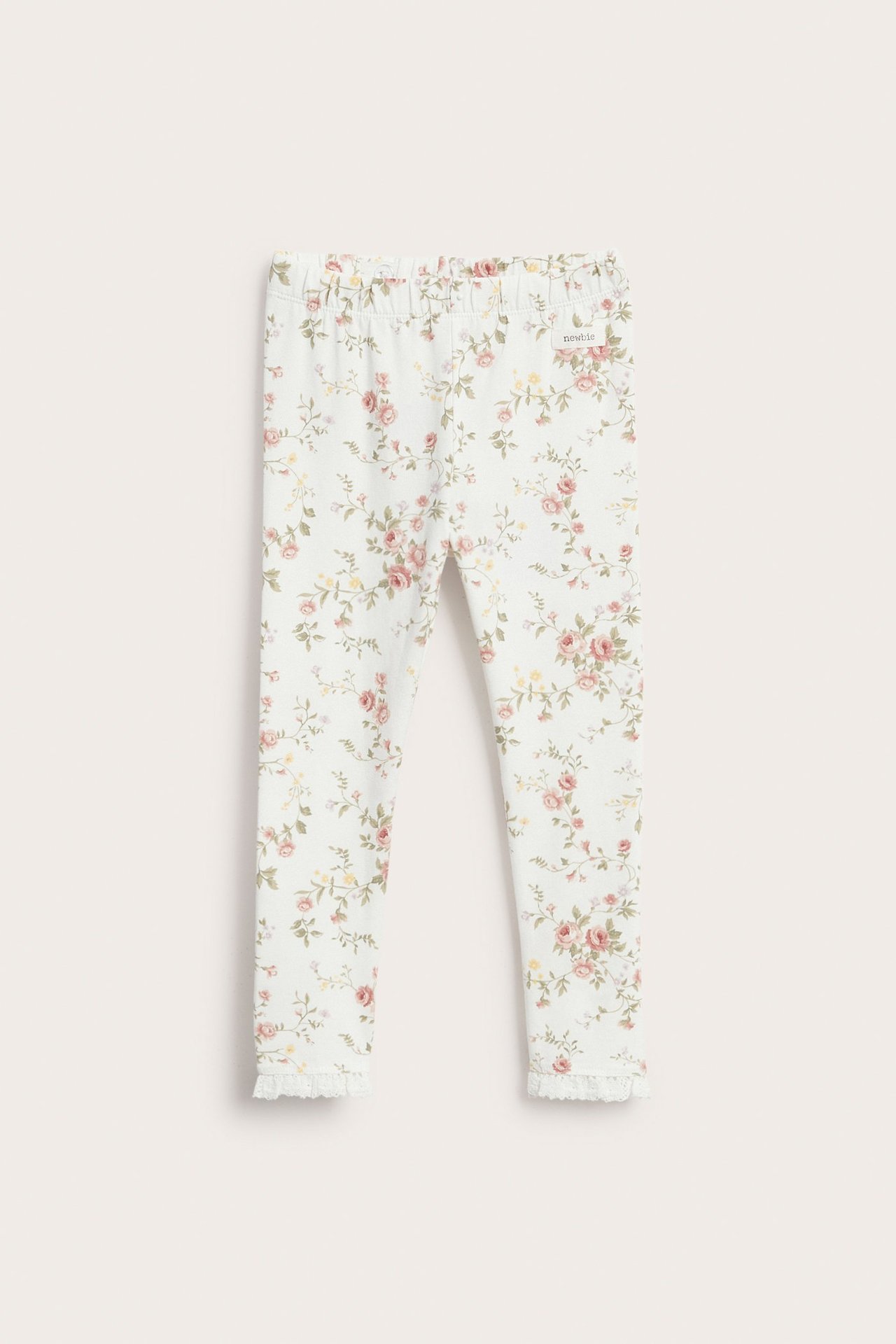 Forfra, offwhite barn-leggings med blomstermønster, blondekant ved benåpningene og elastisk midje.