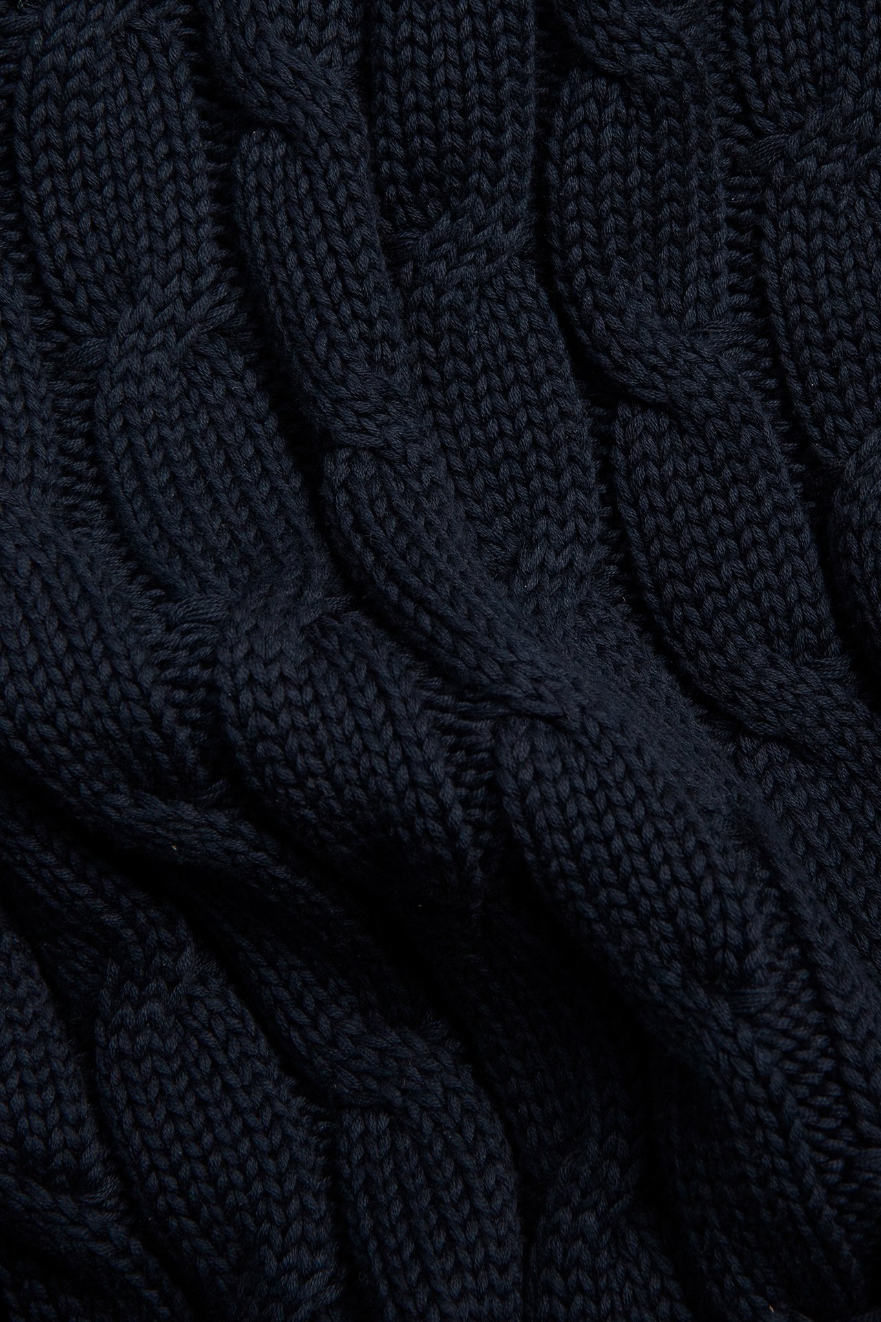 Lähikuva tummansinisestä palmikkoneuleisesta puuvillapuserosta.