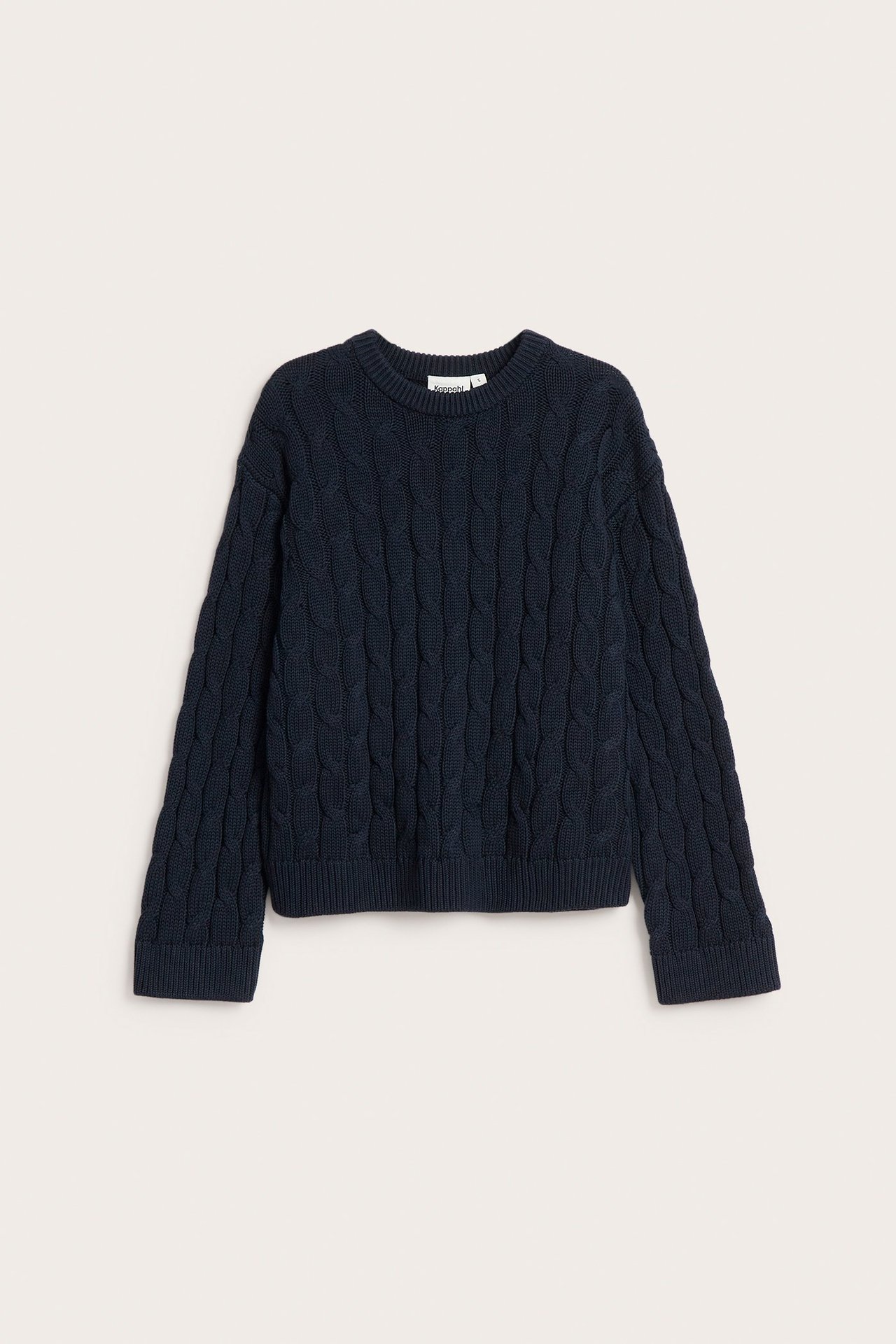 Frontbilde av en mørkeblå kabelstrikket bomullsgenser med rund hals.