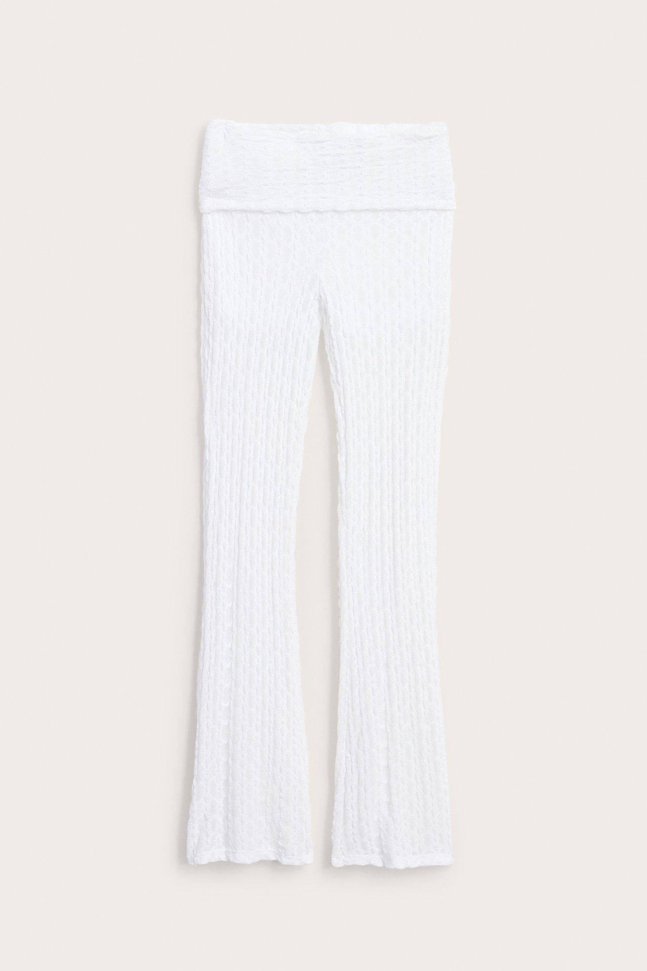 Edestä valkoiset kuvioidut joogahousut taitettavalla vyötäröllä ja hieman levenevillä lahkeilla.