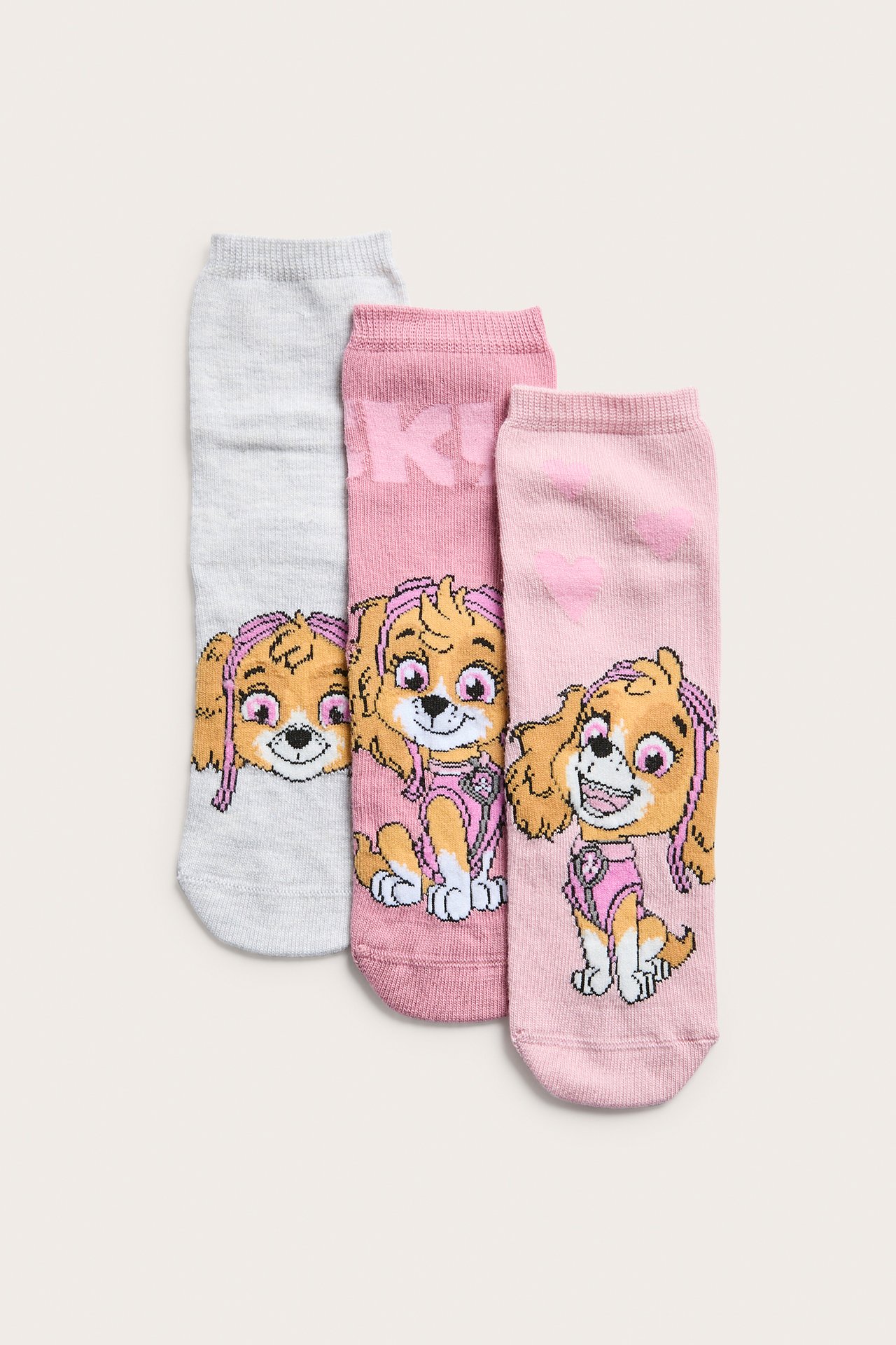 Edestä kolme lasten nilkkasukkaa: harmaa, pinkki ja vaaleanpunainen, Paw Patrol -painatuksella.