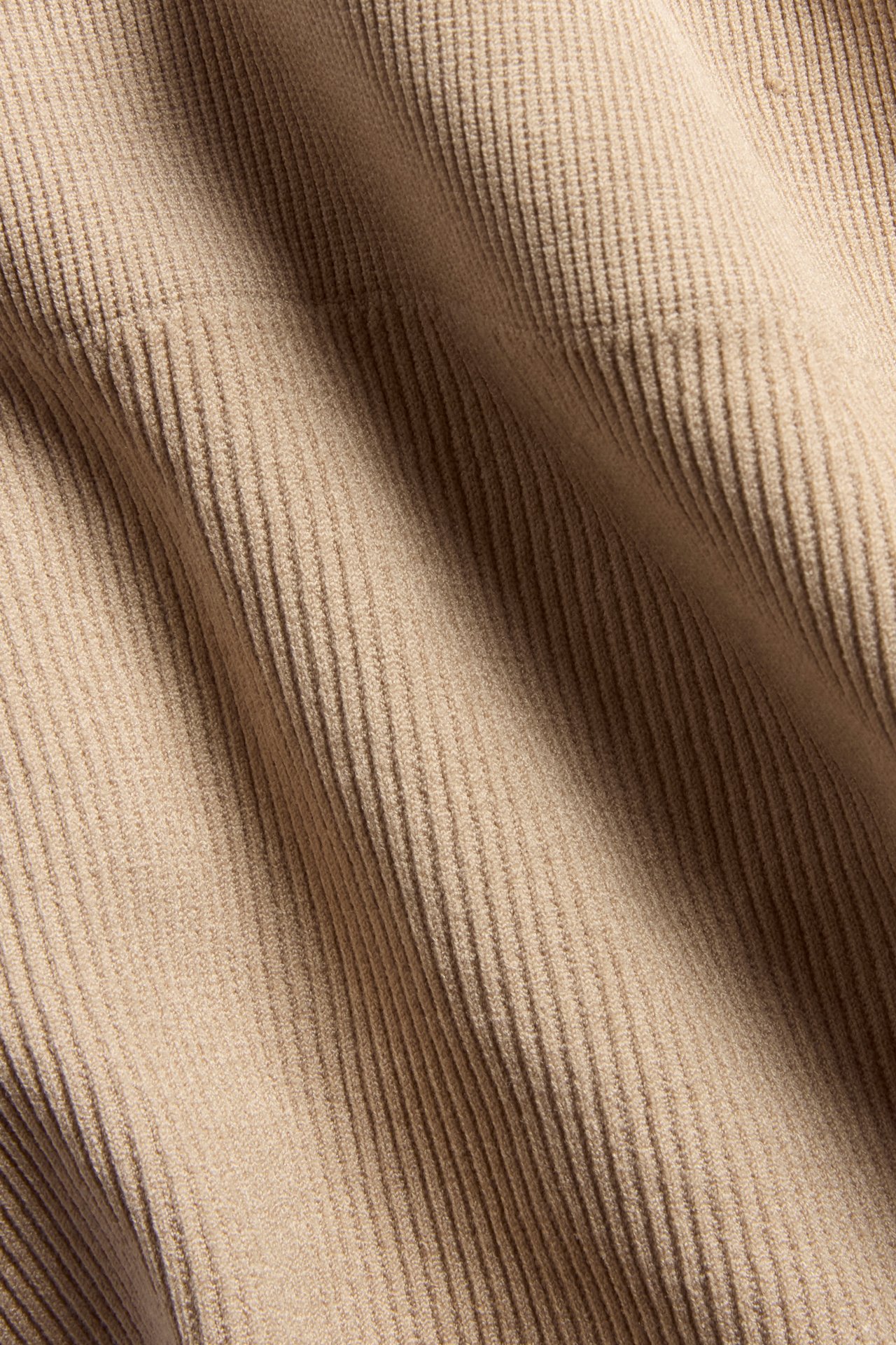 Närbild av det bruna ribbade tyget för en sömlös stringtrosa.