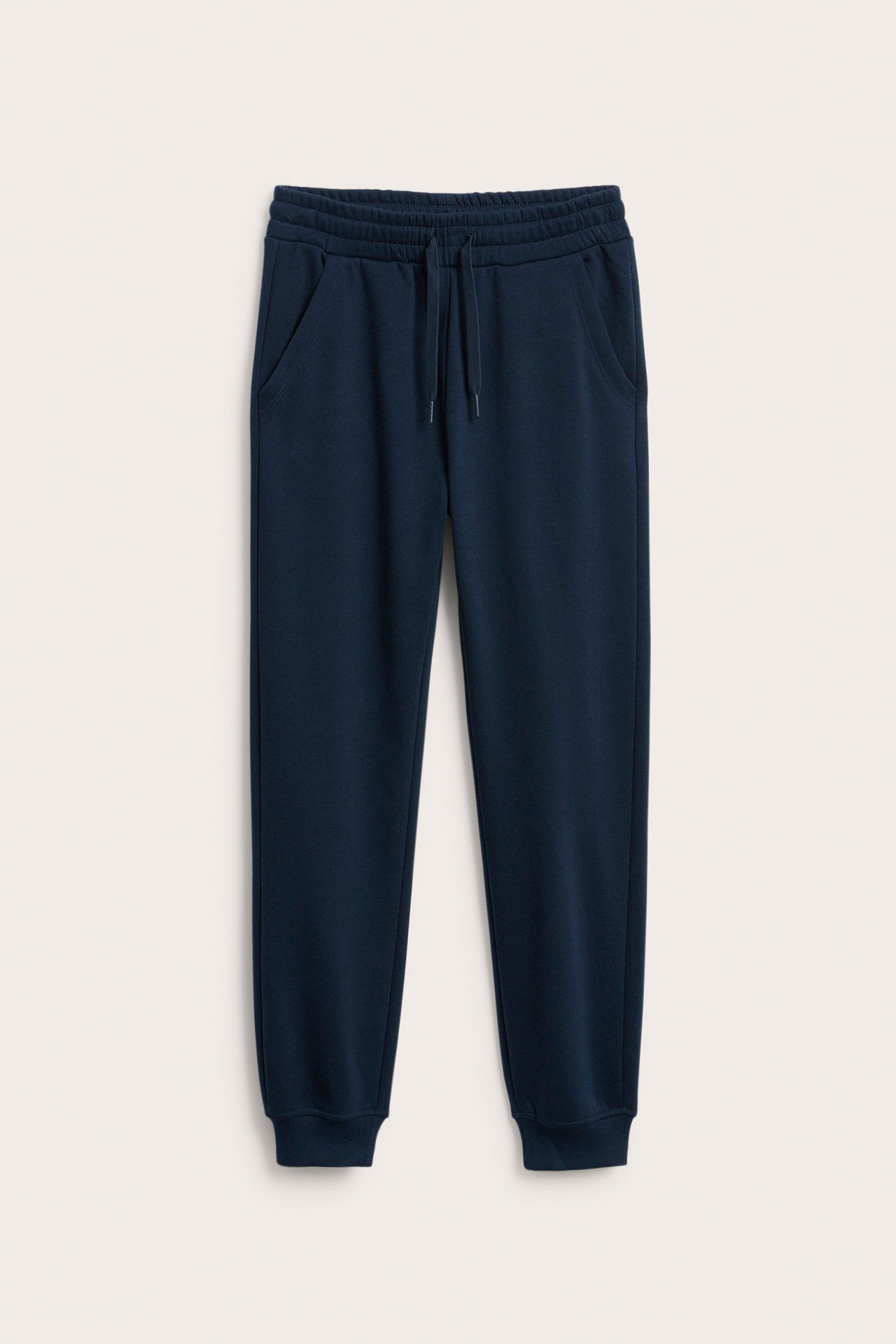 Z przodu ciemnoniebieskie dresy ze sznurkiem w pasie, bocznymi kieszeniami i elastycznymi ściągaczami.