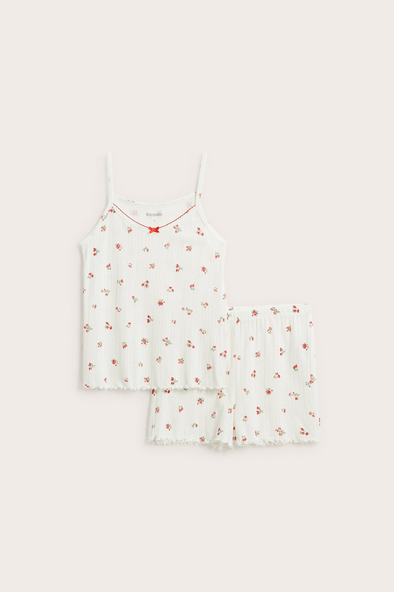Forfra: Hvit bomullspointelle pyjamas med rødt blomstermønster. Topp med rød kant og shorts.