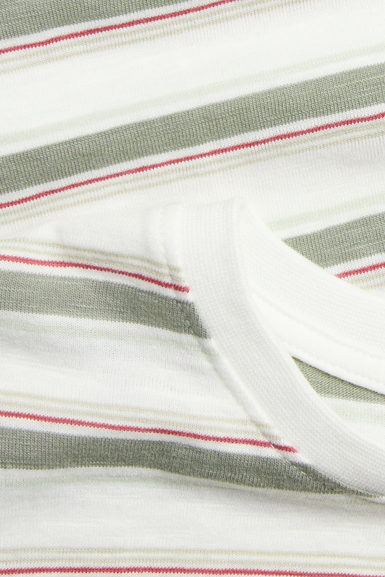 Zbliżenie na ecru pasiasty T-shirt z bawełny slub z szałwiowymi, beżowymi i czerwonymi paskami.