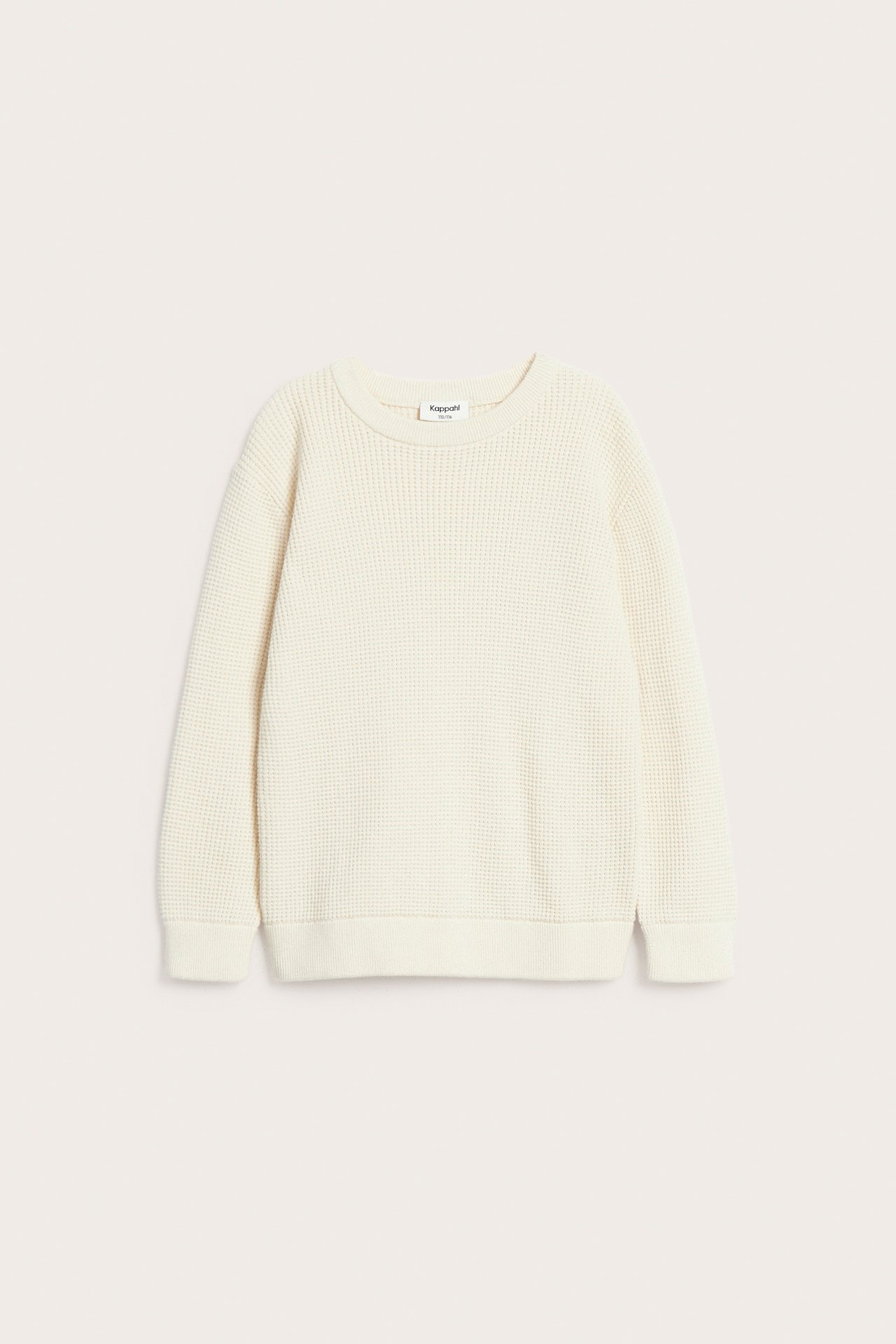 Frontvisning av en finstrikket lys beige bomullsgenser for barn med lange ermer og ribbestrikkede detaljer.