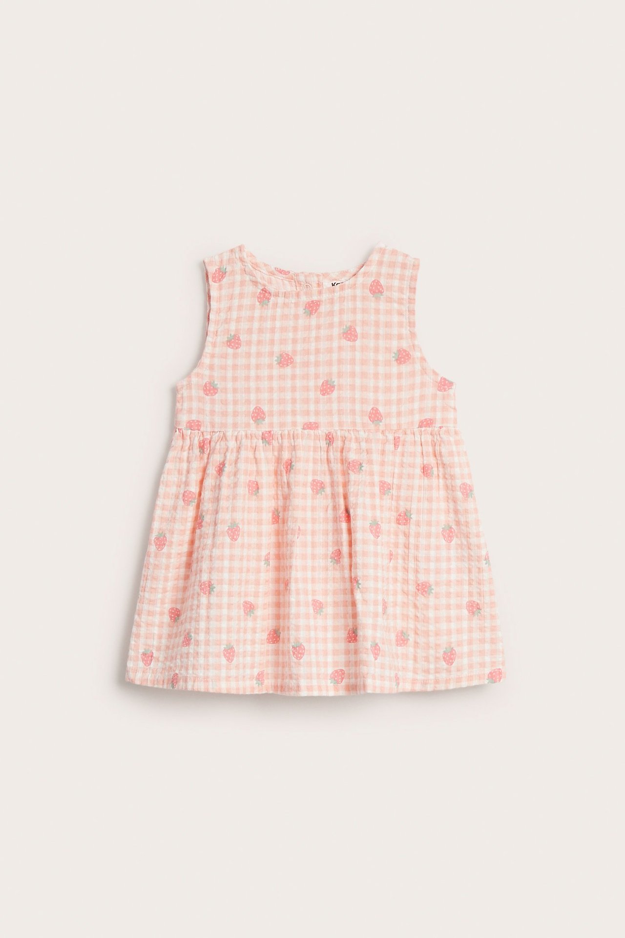 Jasnoróżowo-biała sukienka niemowlęca z seersuckeru w kratkę i truskawki, z guzikami z tyłu.