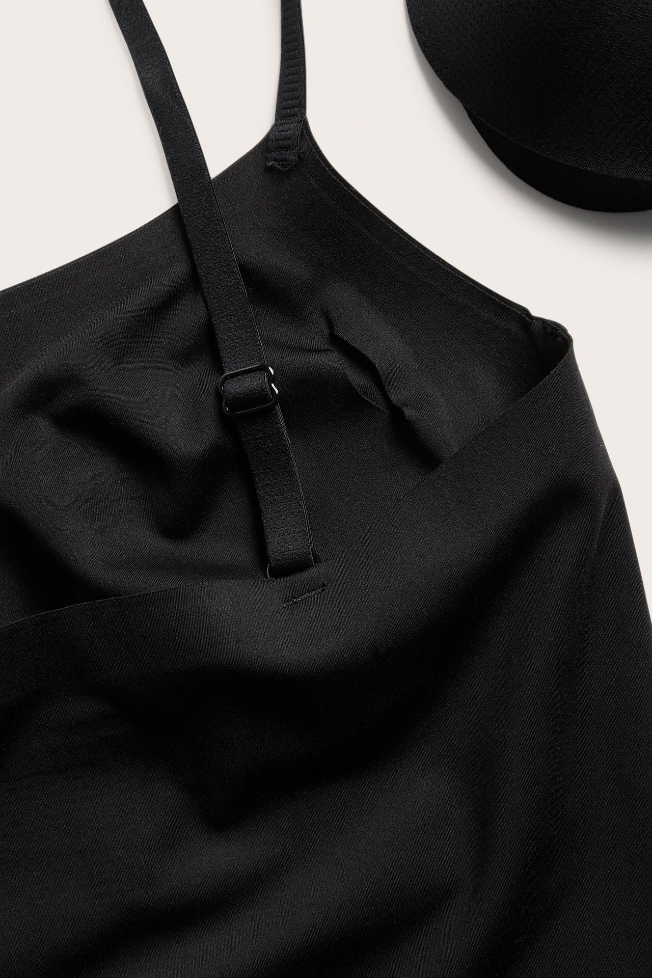 Widok z góry na czarny, bezszwowy biustonosz z regulowanymi ramiączkami i wyjmowanymi wkładkami.