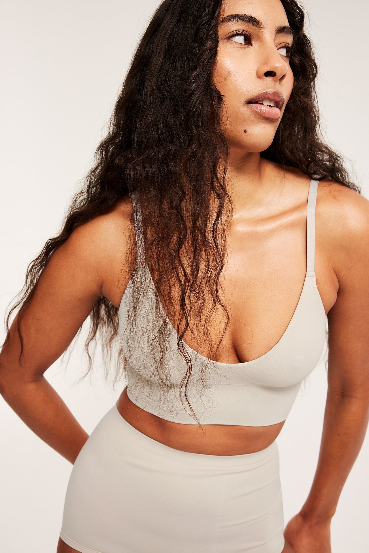 Zbliżenie kobiety w kremowym, bezszwowym biustonoszu z cienkimi ramiączkami i pasującymi majtkami.