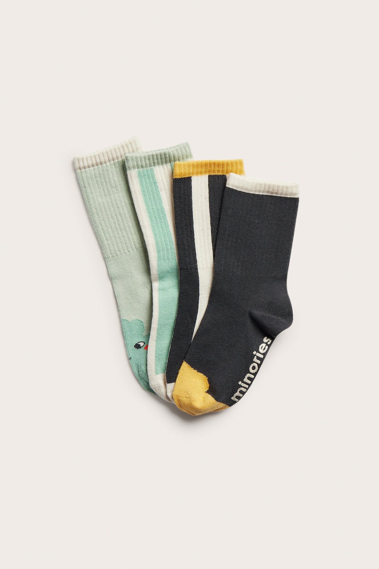 Ovenfra, fire par mønstrede barnesokker: mørkegrå med gul tå, stripete og lysegrønne med dyremønster.