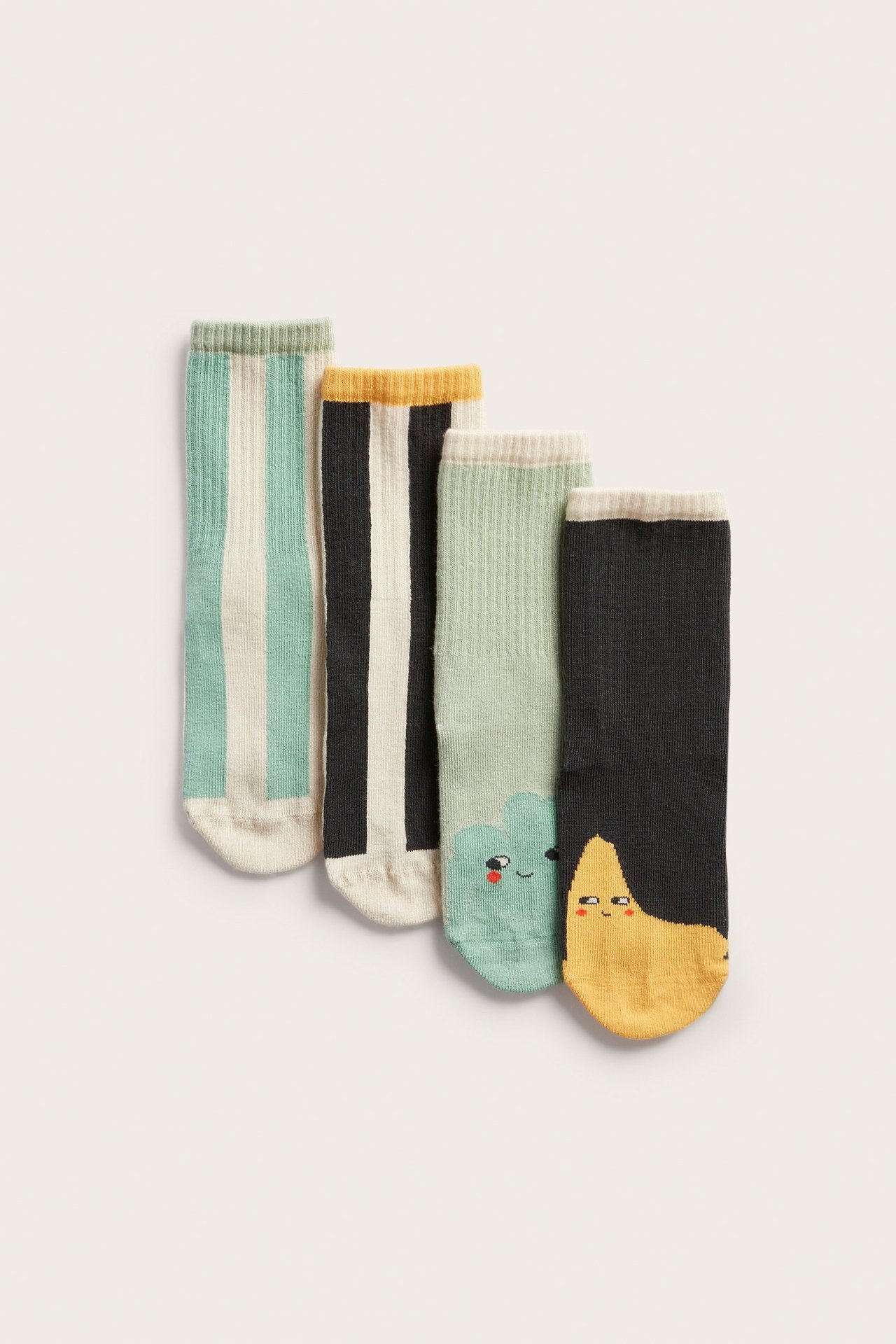 Edestä: Neljä paria lasten puuvillasekoitesukkia vihreänä, mustana, valkoisena, keltaisena, raidoilla ja leikkisillä kuvioilla.