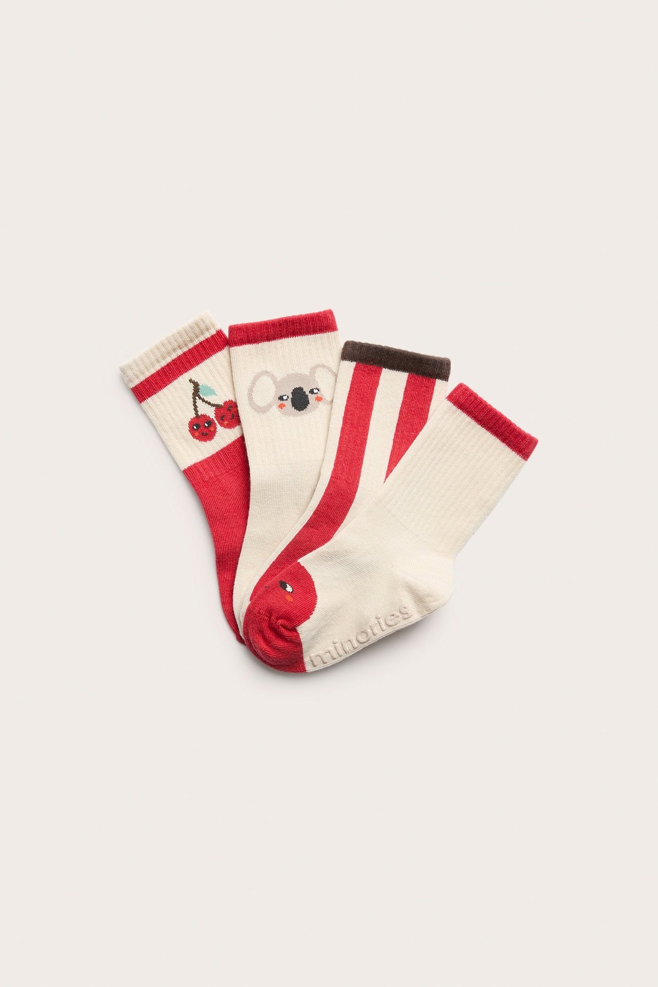Widok z przodu: cztery dziecięce bawełniane skarpetki w kremowo-czerwone wzory wiśni, koali i paski.