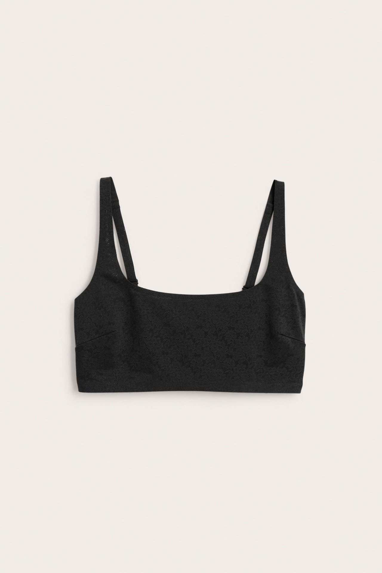 Edestä: Musta pehmustamaton, kaaritueton rintaliivi joustavasta pitsistä ja säädettävillä olkaimilla.