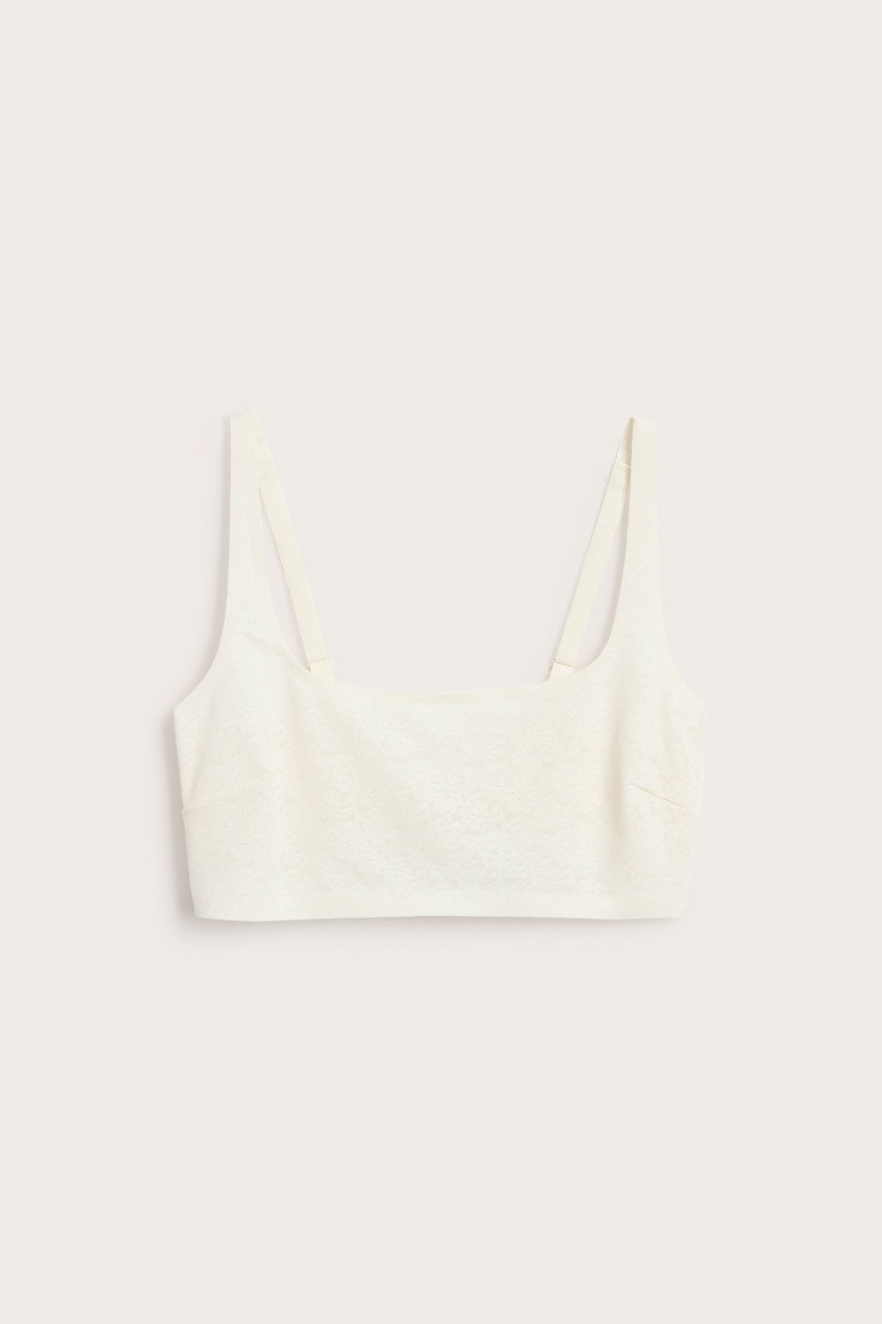 Edestä näkymä luonnonvalkoisista, langattomista, joustavista pitsirintaliiveistä, säädettävillä olkaimilla.