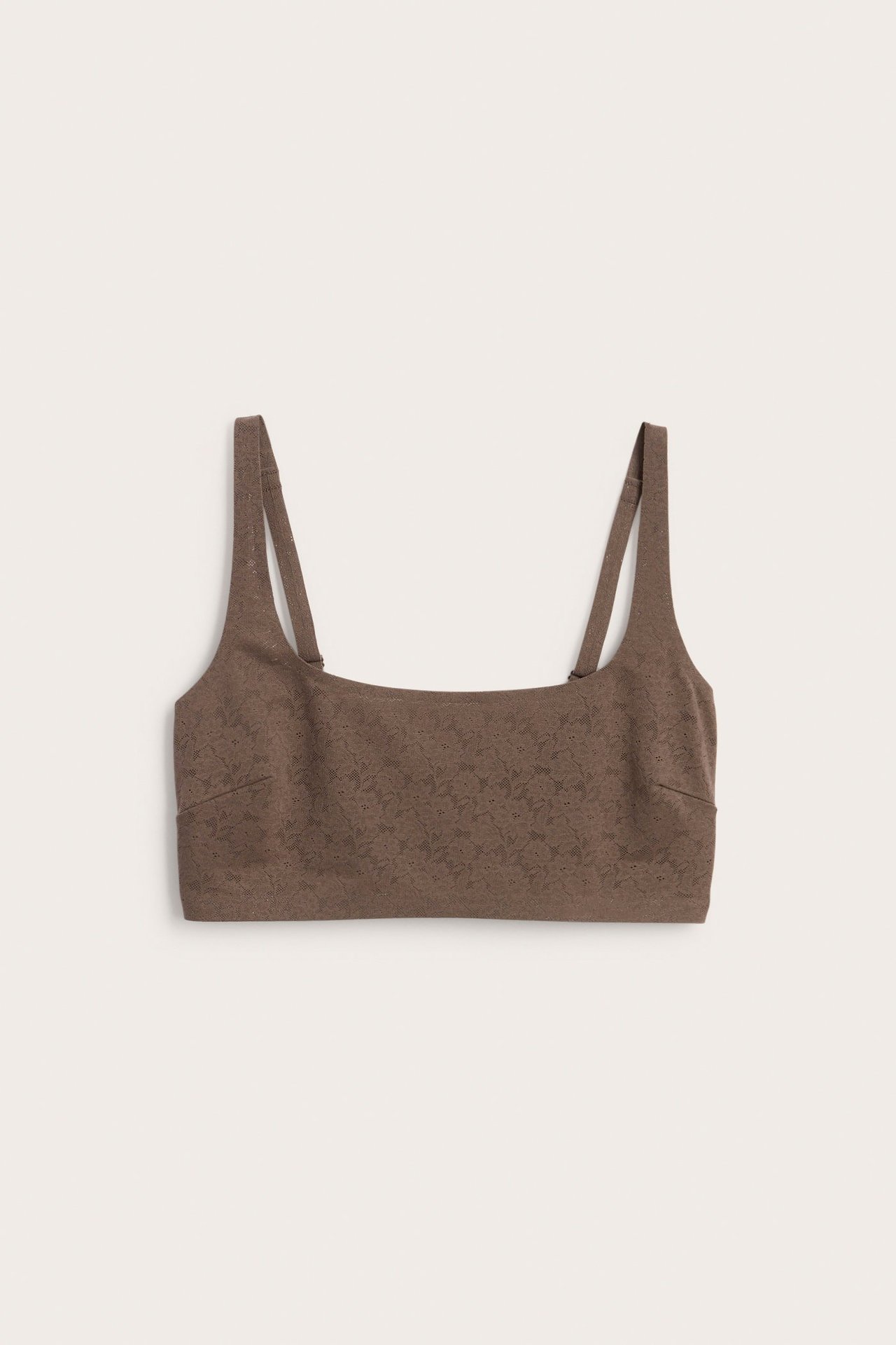 Edestä näkymä tummanruskeasta kaarittomasta pehmeästä pitsirintaliivistä säädettävillä olkaimilla.