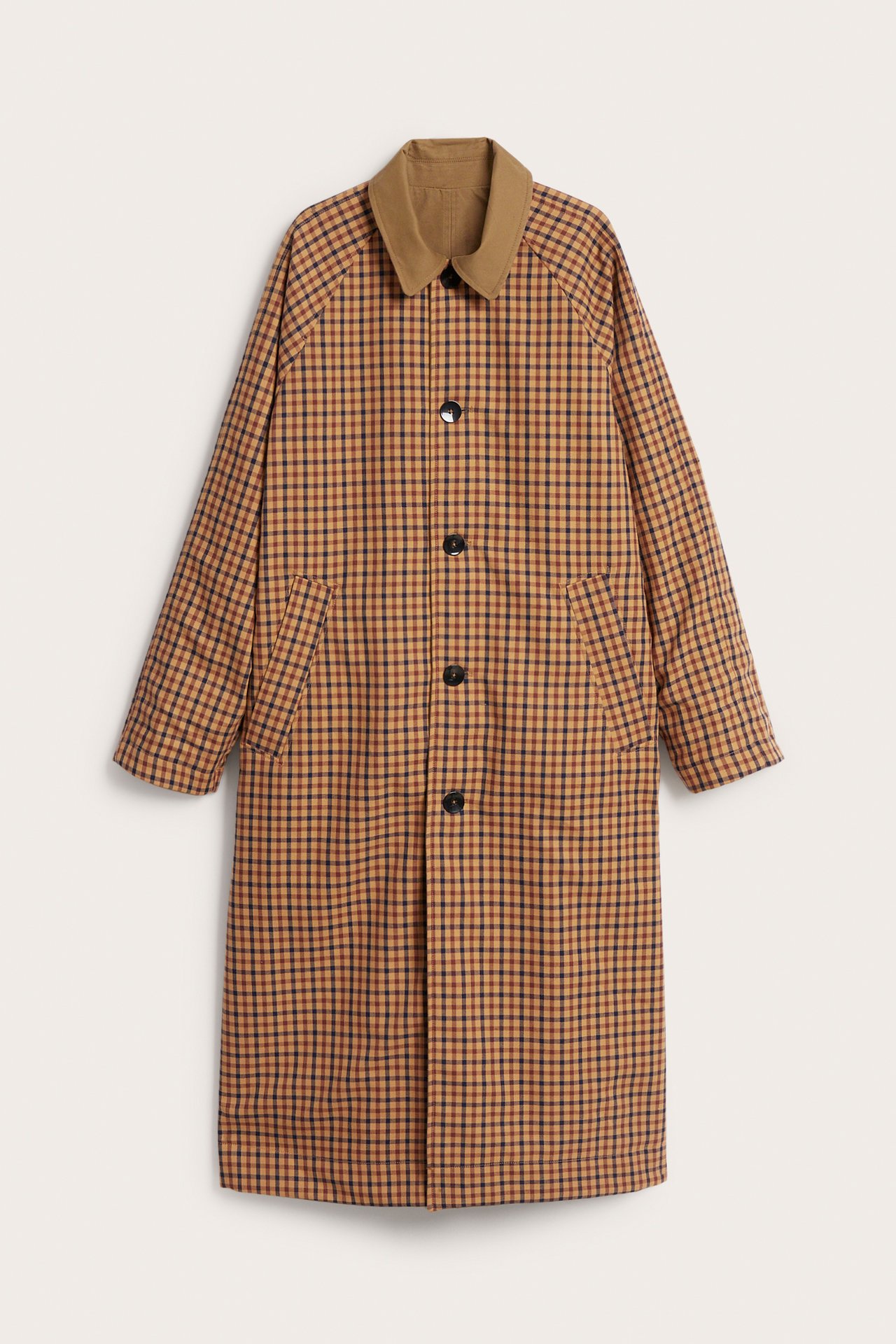 Frontbilde: Vendbar beige rutete trenchcoat med knappelukking, ensfarget beige krage og frontlommer.