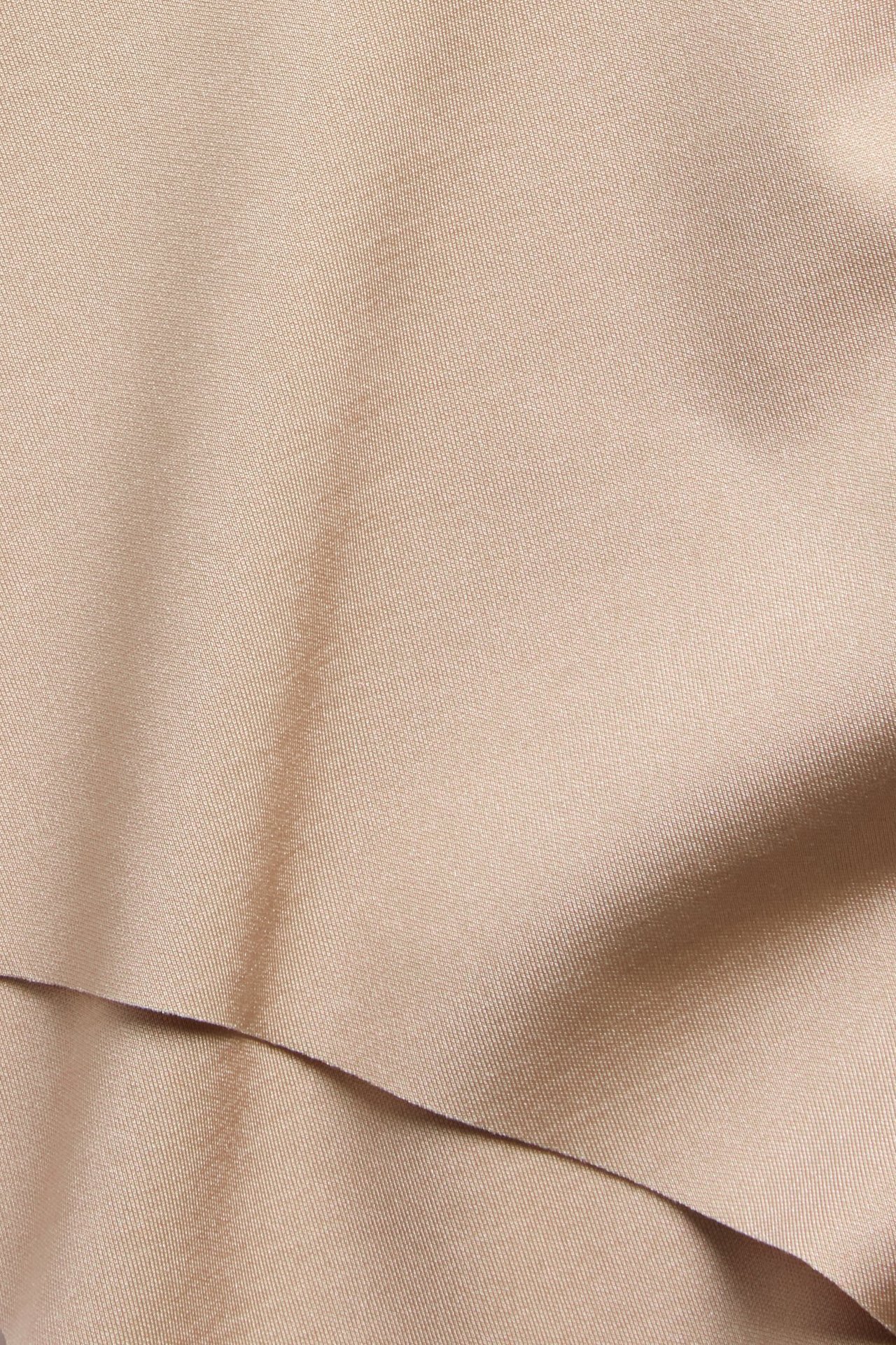 Lähikuva beigestä, yksivärisestä light shape -alushousukankaasta hienovaraisin taitoksin.