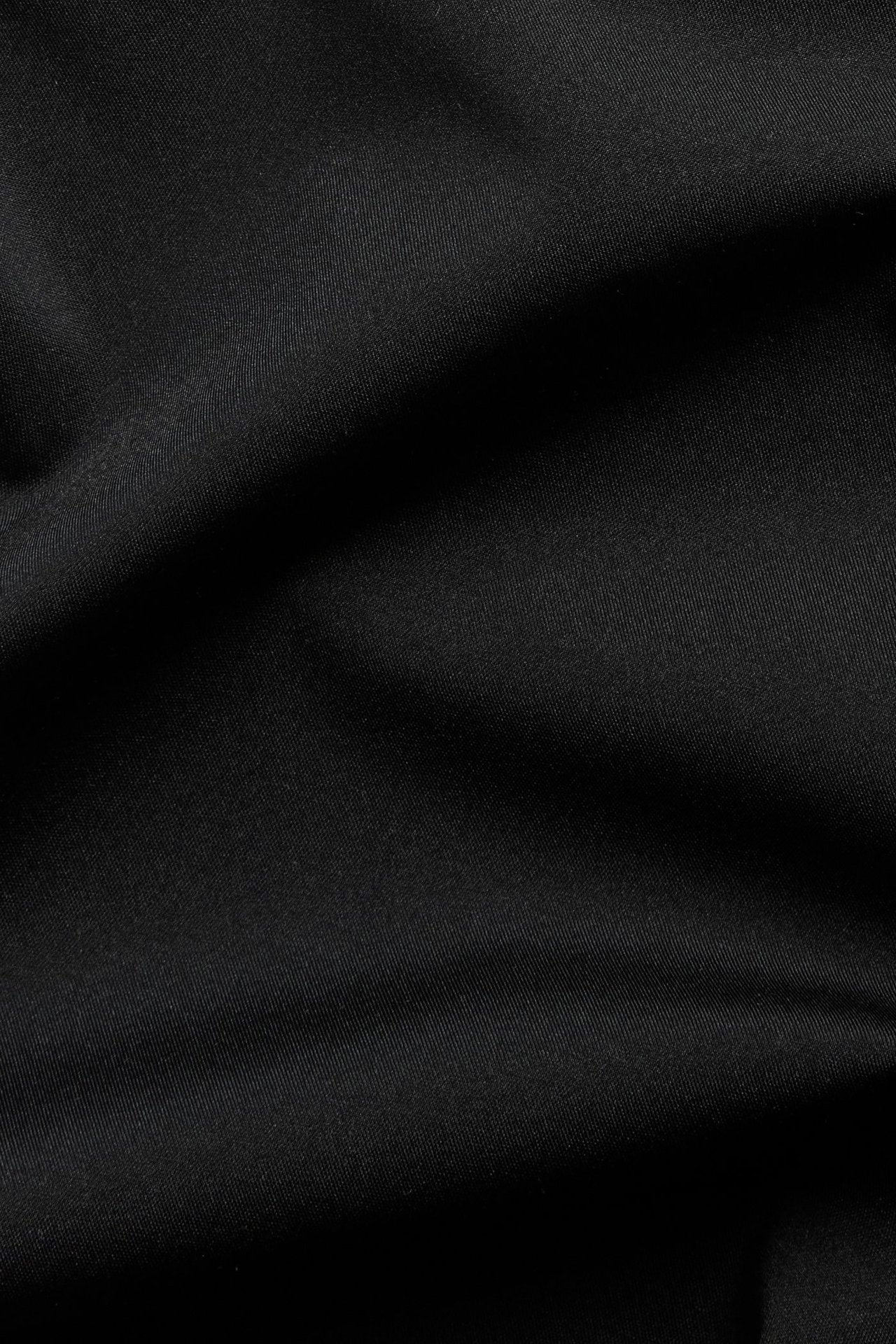 Lähikuva mustista saumattomista kevyesti muokkaavista shortseista, sileä, yksivärinen kangas.