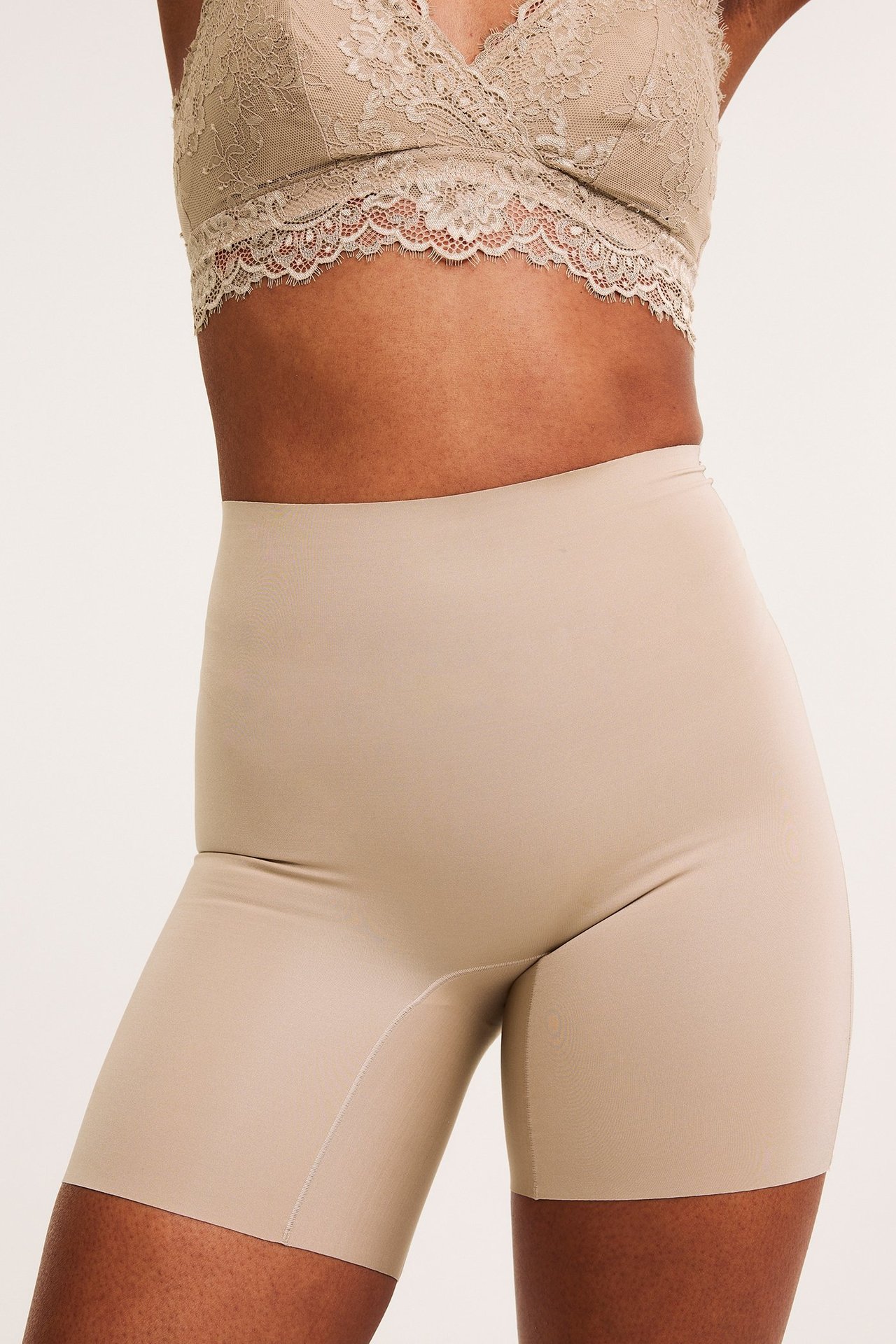 Kvinne, front: høy midje sømløse beige shaping-shorts og en matchende blonde-BH.