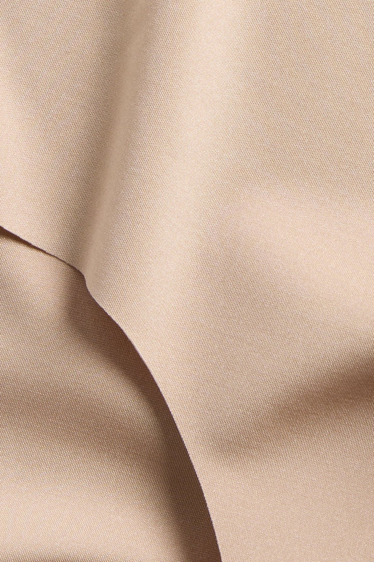 Zbliżenie jasnobrązowej teksturowanej tkaniny z miękkimi fałdami.