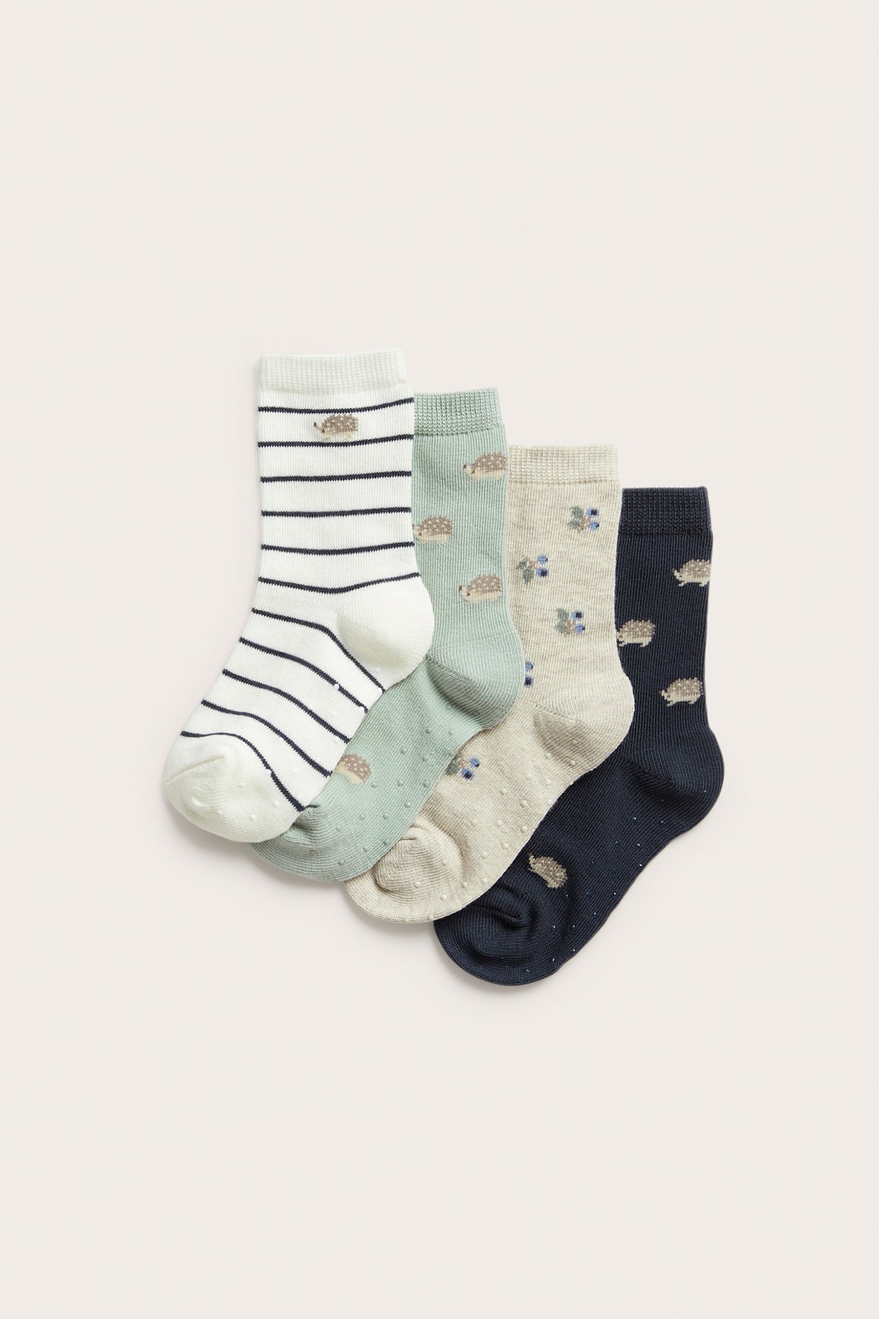 Widok czterech wzorzystych skarpetek dziecięcych: granatowe, zielone, w paski, beżowe, z jeżami, jagodami, antypoślizgiem.