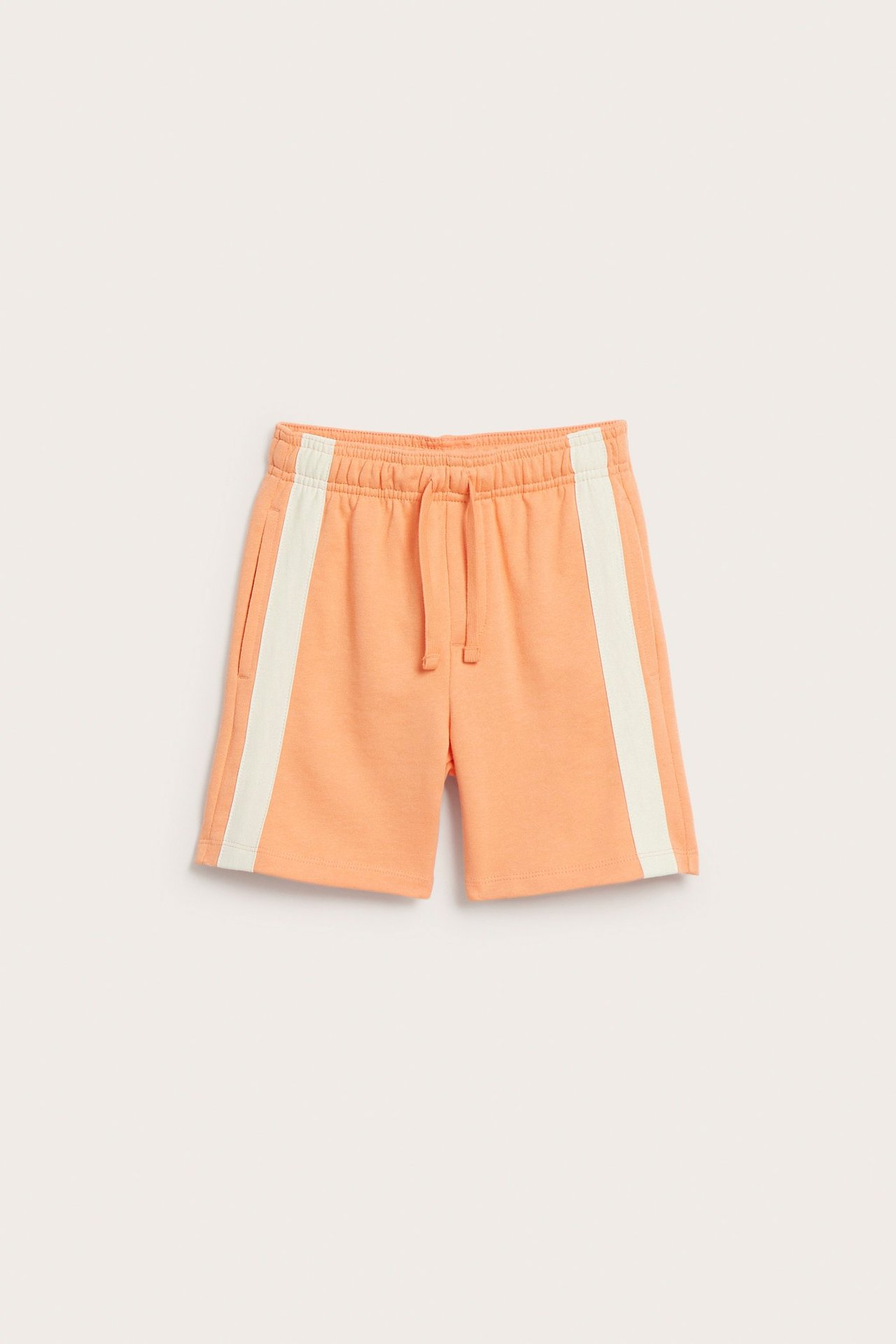 Oranssit collegeshortsit edestä, valkoisilla sivuraidoilla, joustavalla vyötäröllä ja koristekiristysnyöreillä.