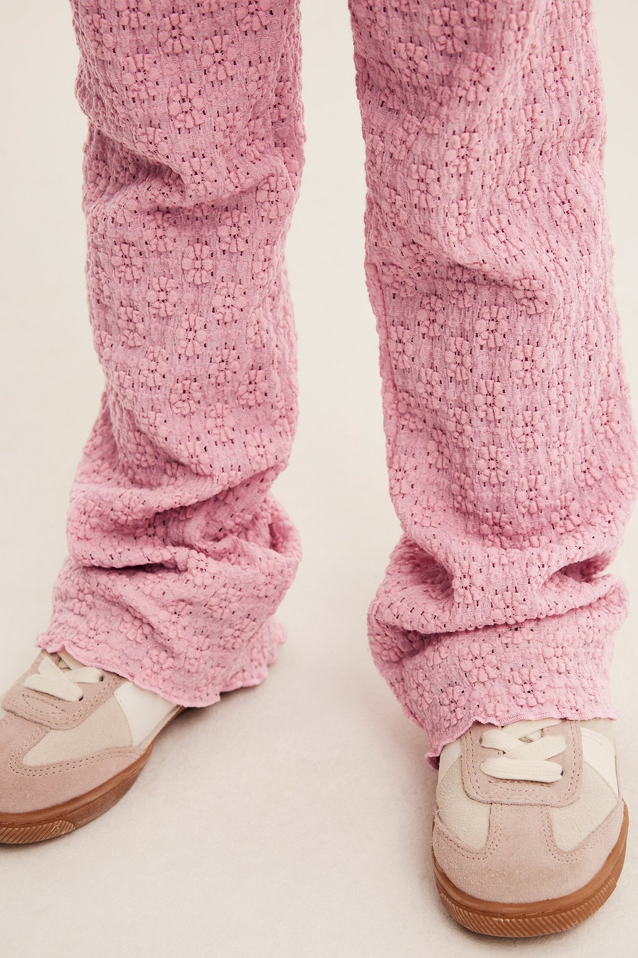 Frontbilde av barn i lyserosa utsvingte blondeleggings og beige-hvite joggesko.