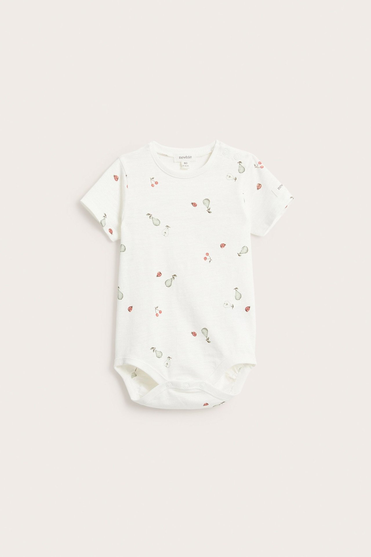 Frontutsikt av en offwhite kortermet babybody i bomull med mønster av pærer, kirsebær og marihøner.