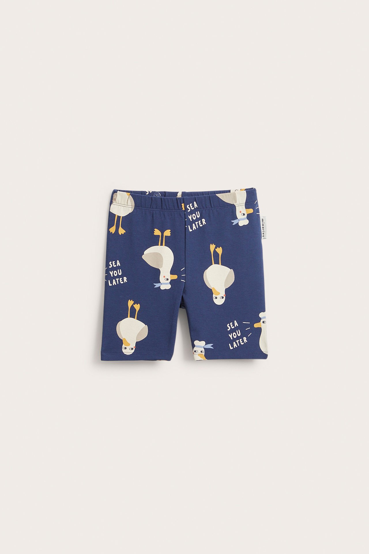 Framsida på barnens blå cykelbyxor med vitt ankprint och texten 'SEA YOU LATER'.