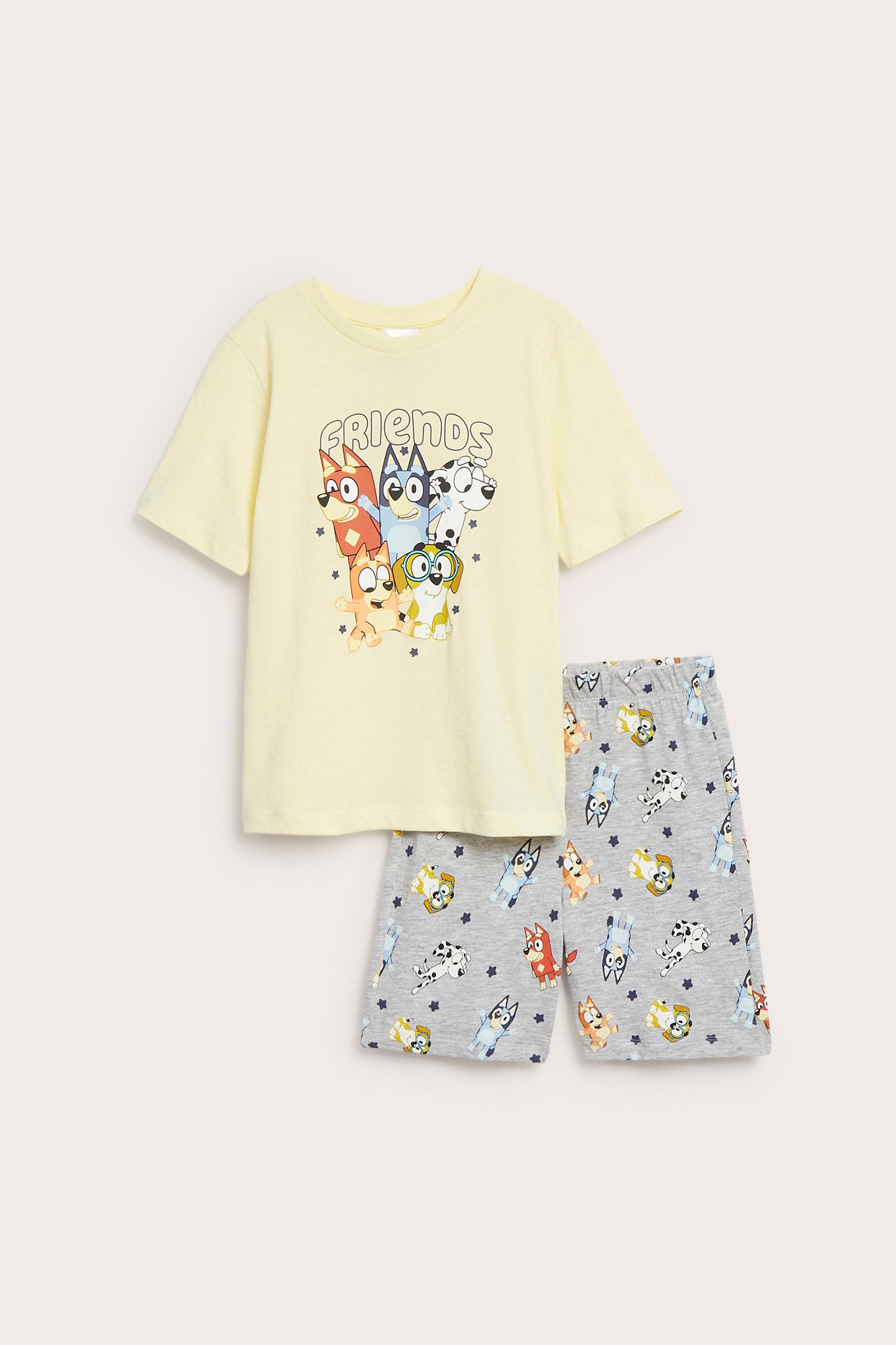Frontvy av en ljusgul Bluey-mönstrad pyjamas-t-shirt och gråmönstrade shorts för barn.