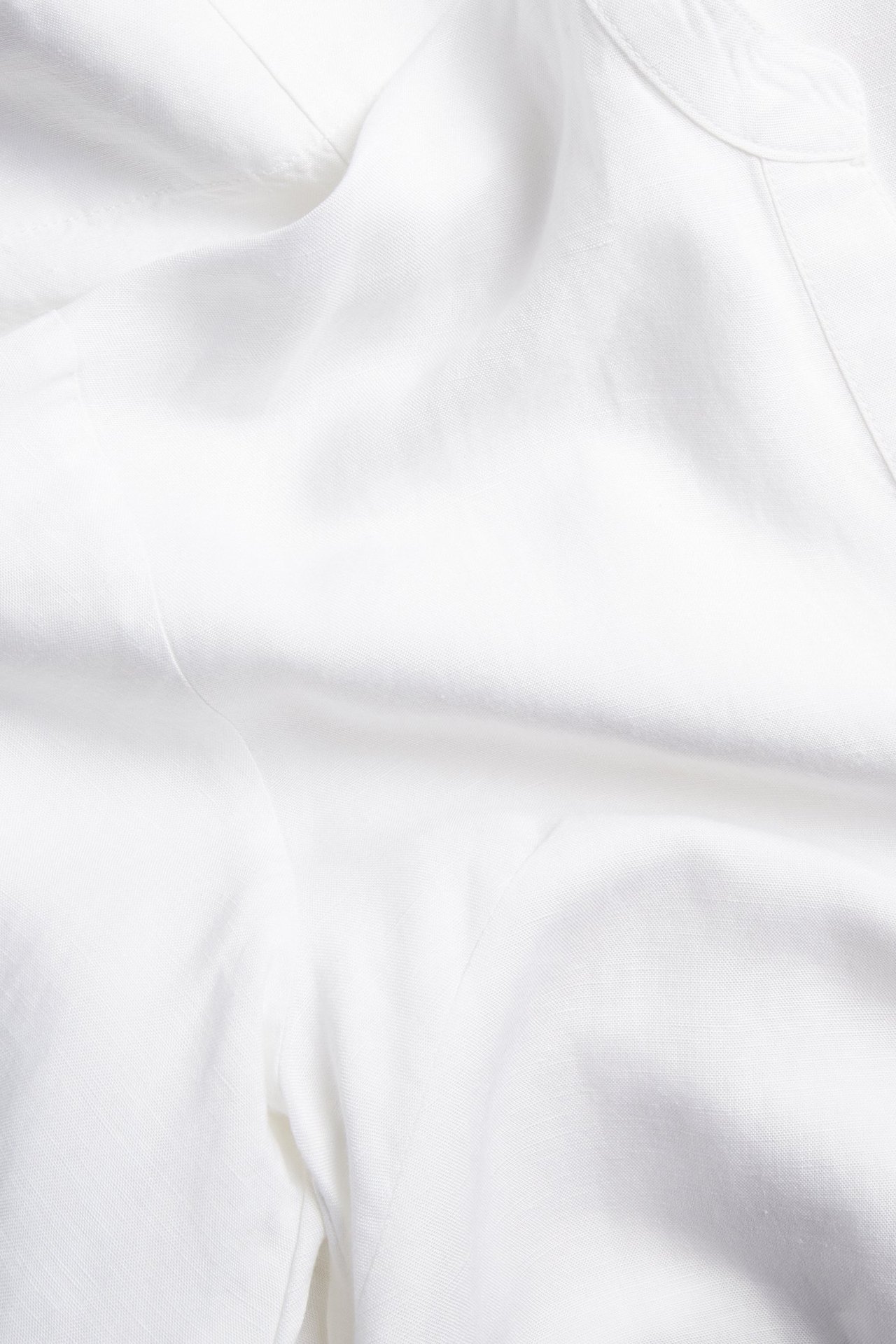 Närbild av vitt linneblandningsklänningstyg med naturliga veck.