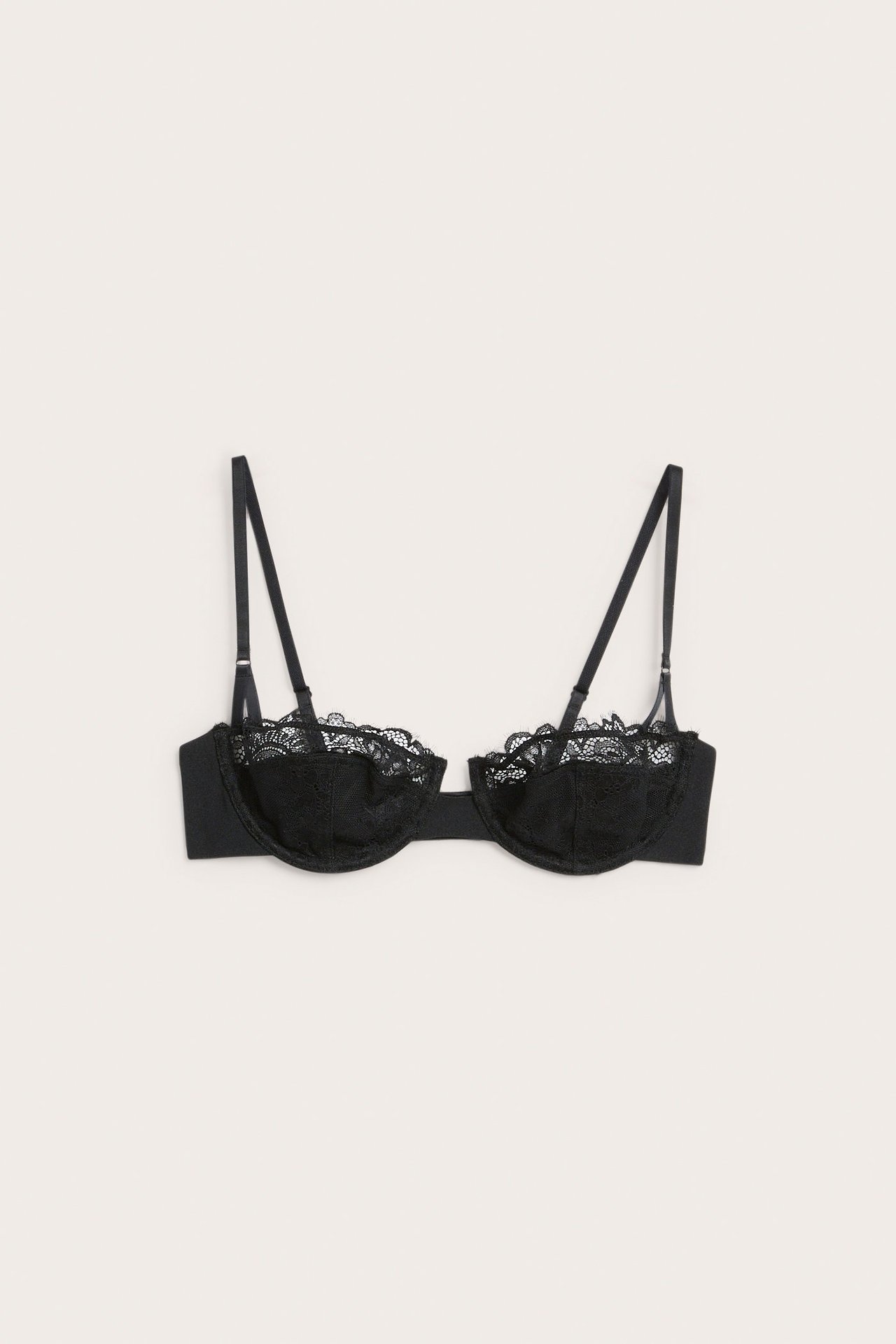 Widok z przodu czarnego biustonosza typu balconette z koronkowym wykończeniem i regulowanymi ramiączkami.
