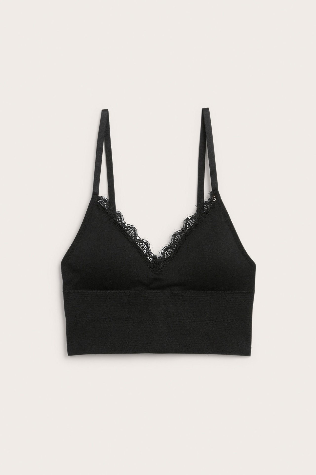 Frontvisning: svart, bøylefri dame-bh med tynne stropper og delikat blondekant i V-halsen.