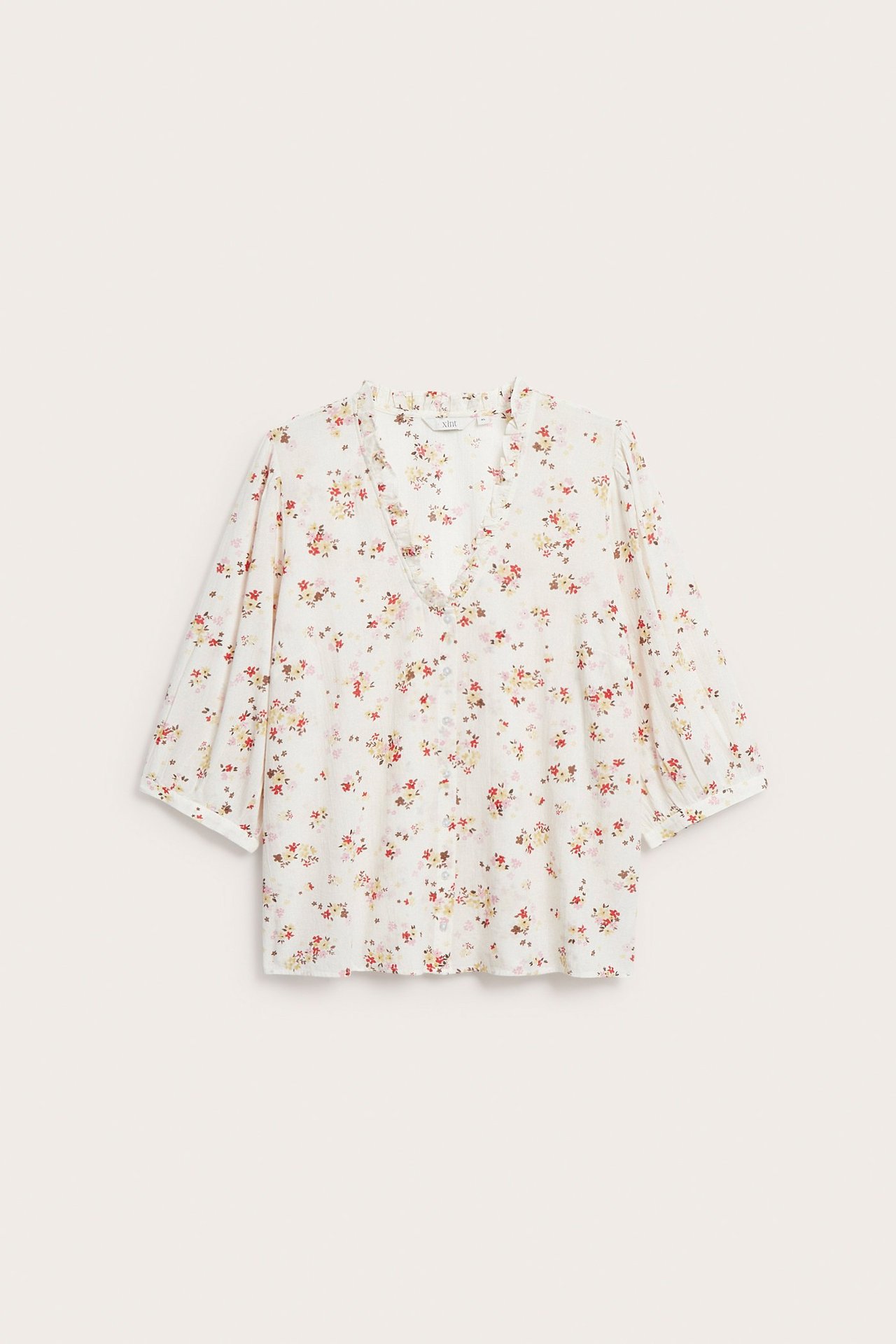 Widok z przodu: ecru bawełniana bluzka w kolorowy kwiatowy wzór, V-dekolt z falbanką, rękawy 3/4 z bufkami.