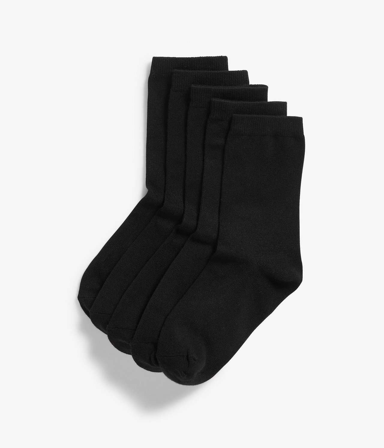 Ylhäältä näkymä viidestä parista yksivärisiä mustia sukkia, siististi pinottuna.