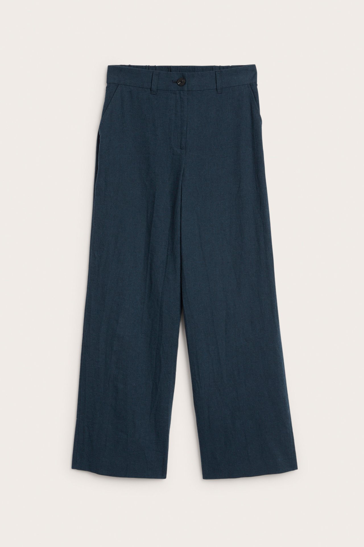 Etunäkymä: Tumman siniset meleratut pellavasekoitehousut, joissa leveät lahkeet, nappi ja sivutaskut.