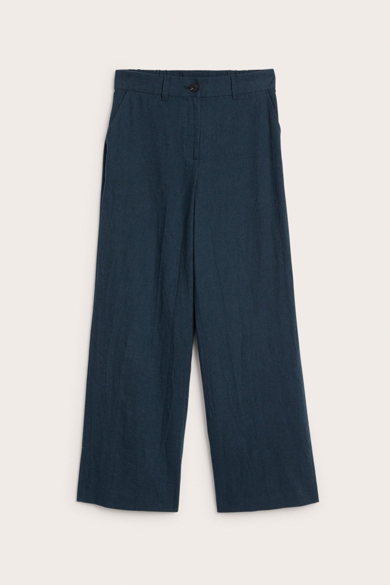 Etunäkymä: Tumman siniset meleratut pellavasekoitehousut, joissa leveät lahkeet, nappi ja sivutaskut.