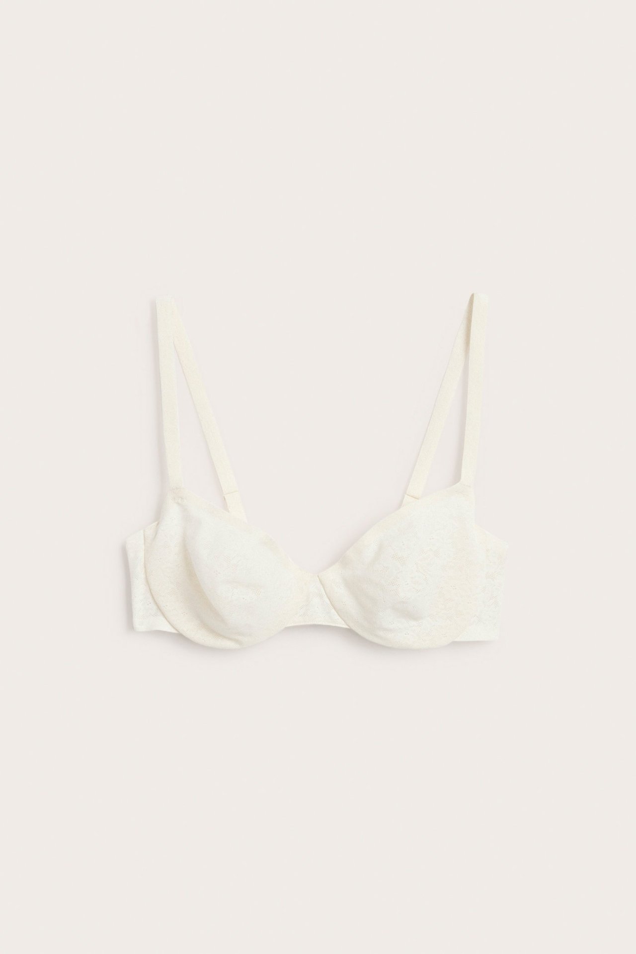 Widok z przodu beżowego biustonosza z fiszbinami o subtelnym koronkowym wzorze.