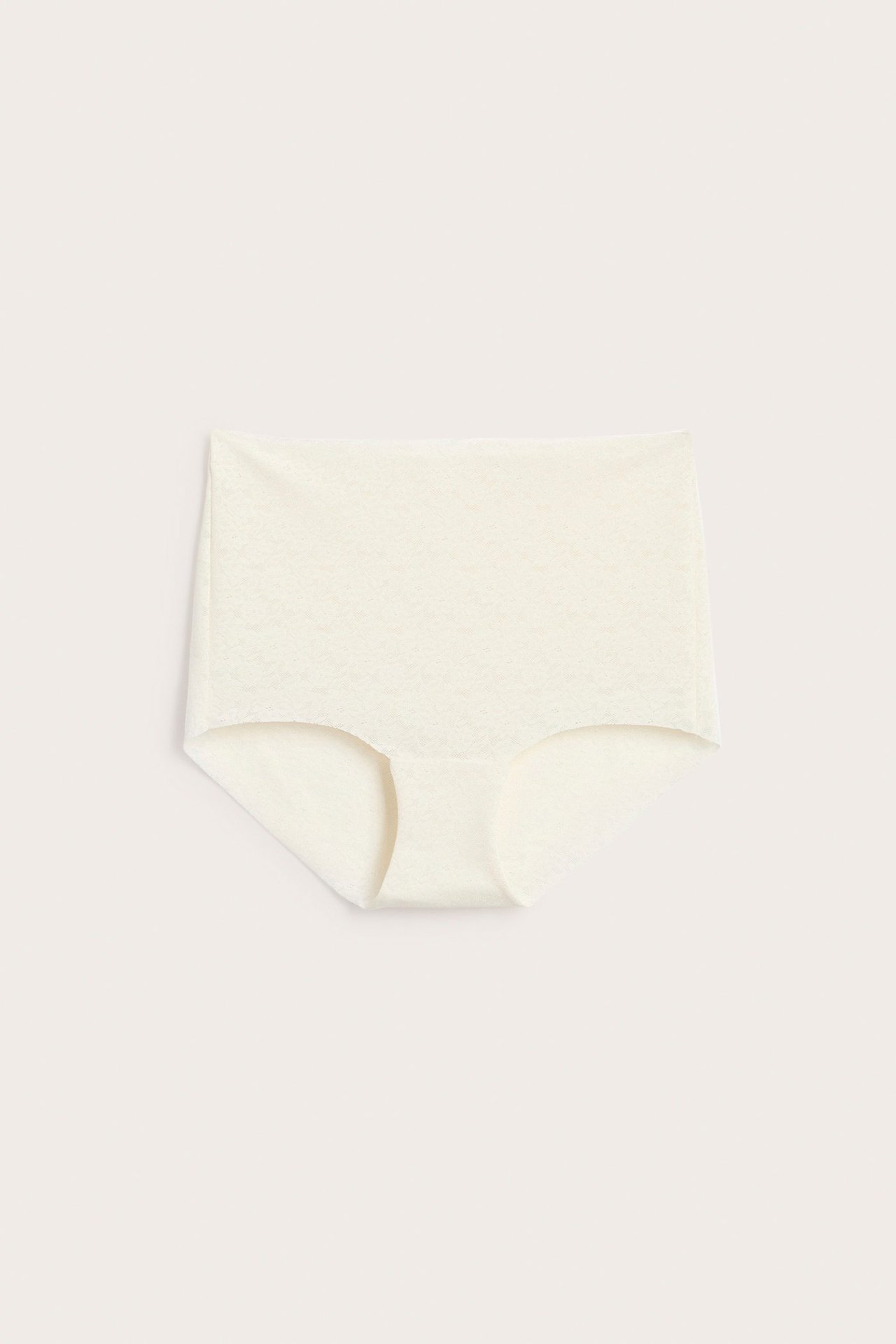 Framifrån: Offwhite stretchig spets-hipstertrosa med rena, osynliga kanter, platt liggande.