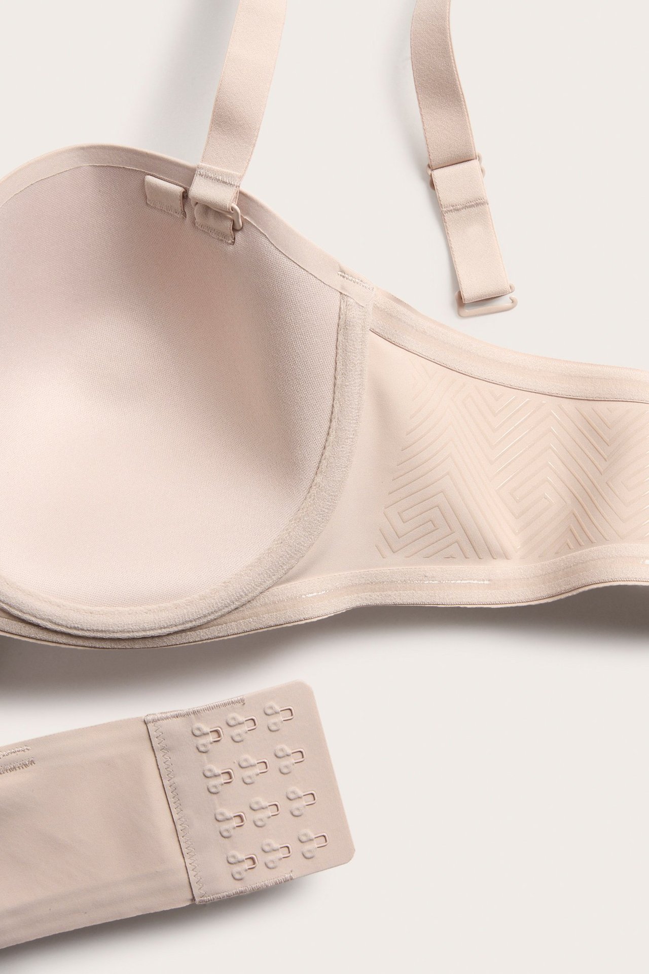 Närbild av en ljusbeige balconette-bh i mikrofiber med avtagbara axelband och hyskknäppning.